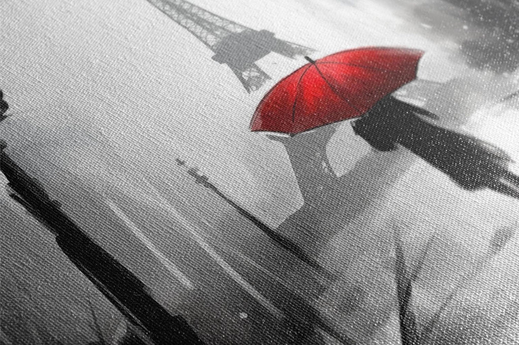 A black and white image of the Eiffel Tower, with a red umbrella in the foreground, creating a striking contrast between the dark silhouette of the tower and the vibrant red umbrella.