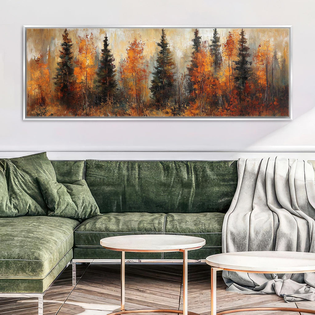 a living room with a large painting of a forest scene hanging on the wall above a green sofa. The sofa is positioned in front of a round coffee table, and there is a white blanket draped over one end of the sofa.