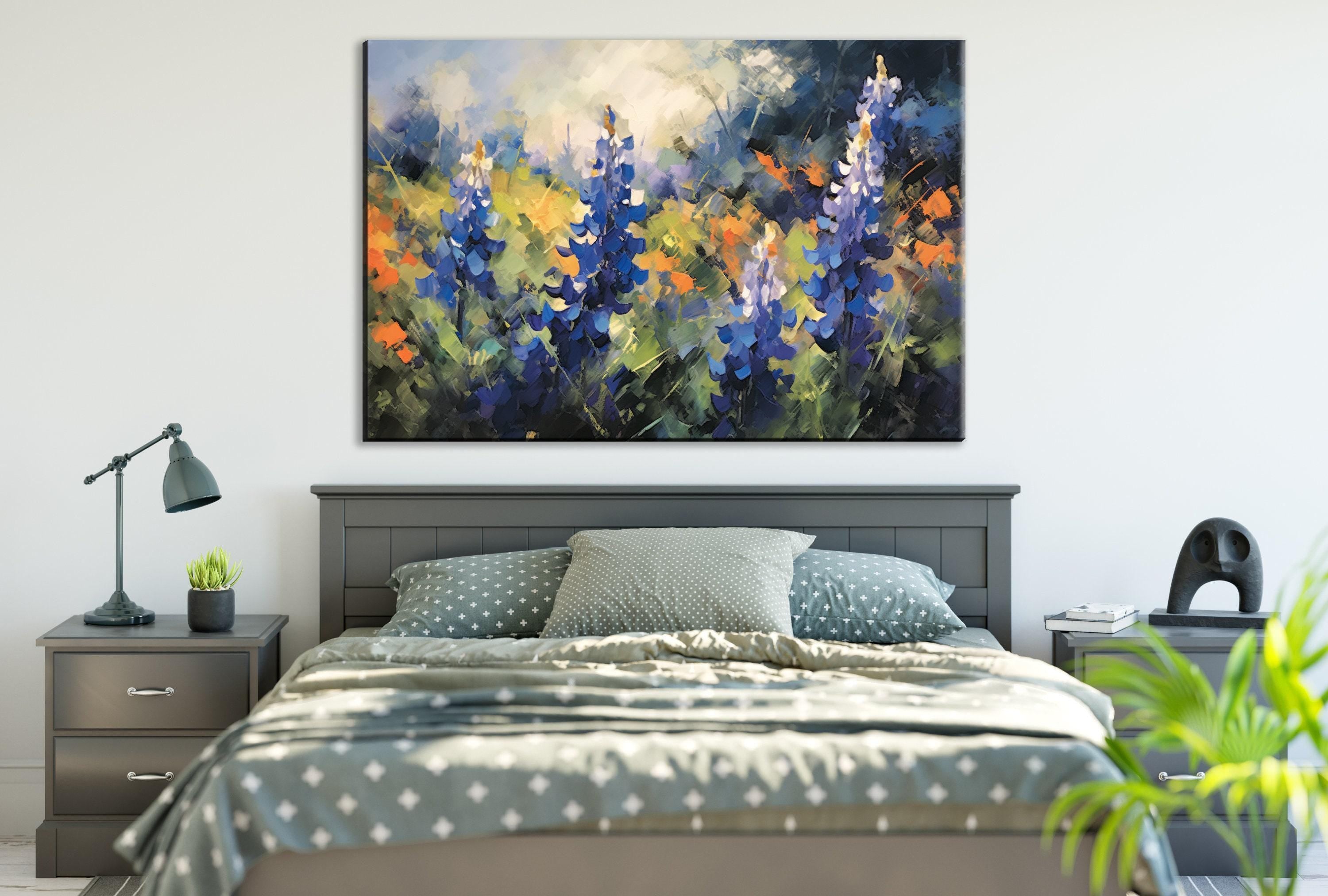 a large painting of colorful flowers hanging above a bed with a gray and white patterned bedspread.