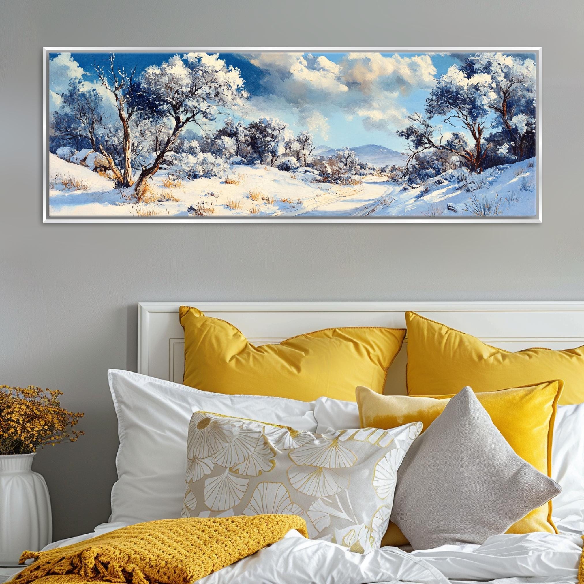 a painting of a snowy landscape on a wall above a bed