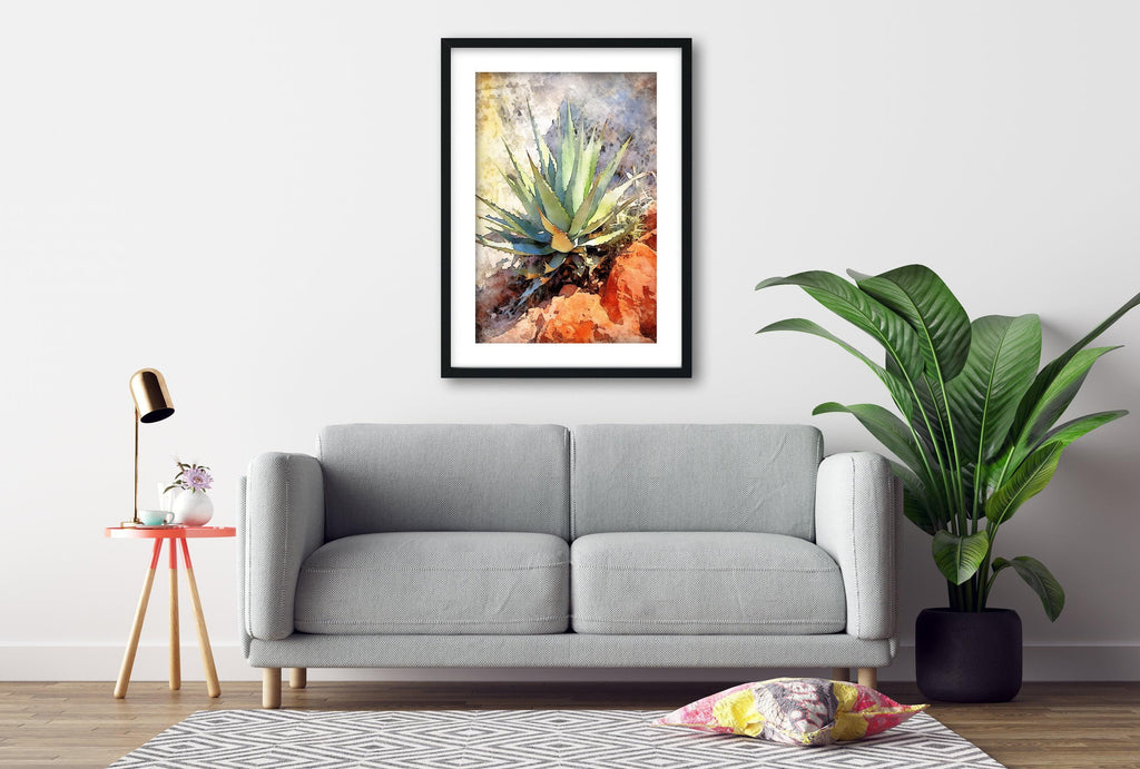 a gray sofa, a framed painting of a cactus plant, a small table with a lamp, and a potted plant, all arranged in a living room setting.