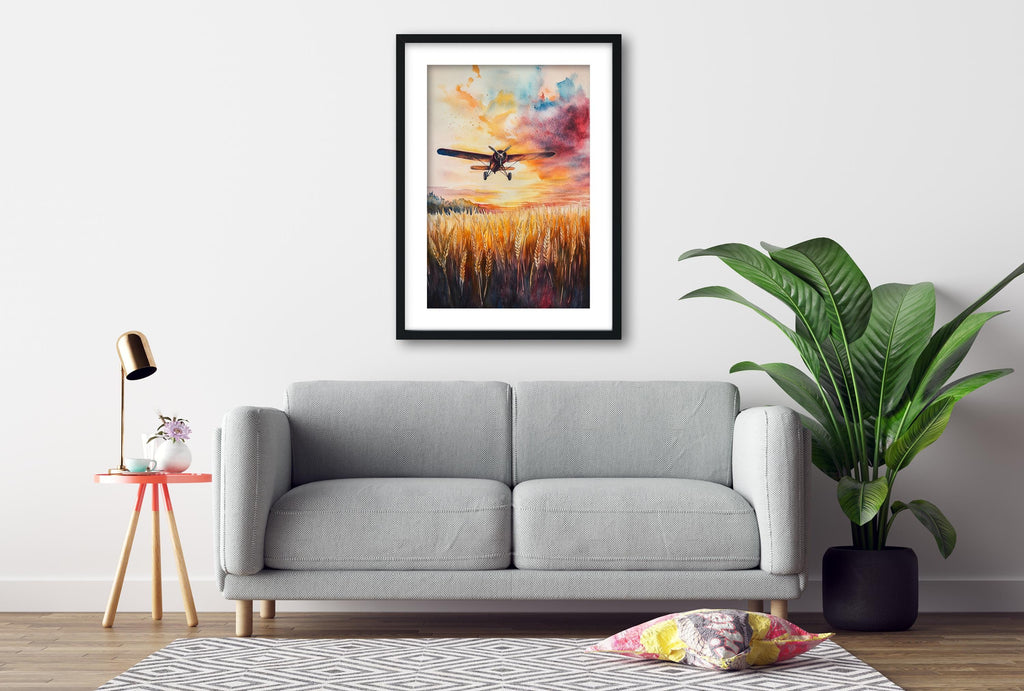 a gray sofa, a framed painting of a plane flying over a field, a small table with a lamp, and a potted plant, all arranged in a living room setting.