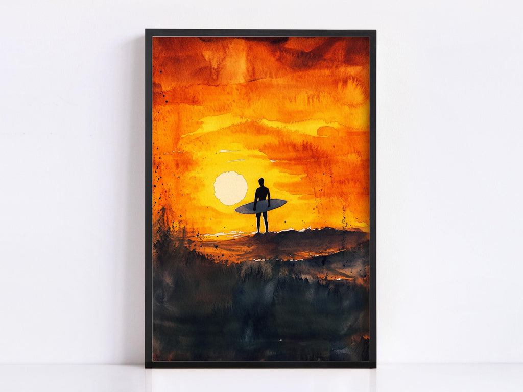 A framed watercolor painting depicting a surfer silhouetted against a vibrant sunset sky.