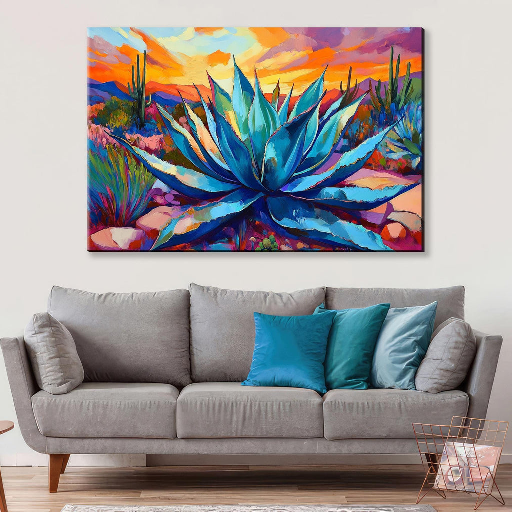 a large, colorful painting of a desert scene with a prominent blue agave plant in the center. The painting is hung on a wall above a gray sofa with blue throw pillows.