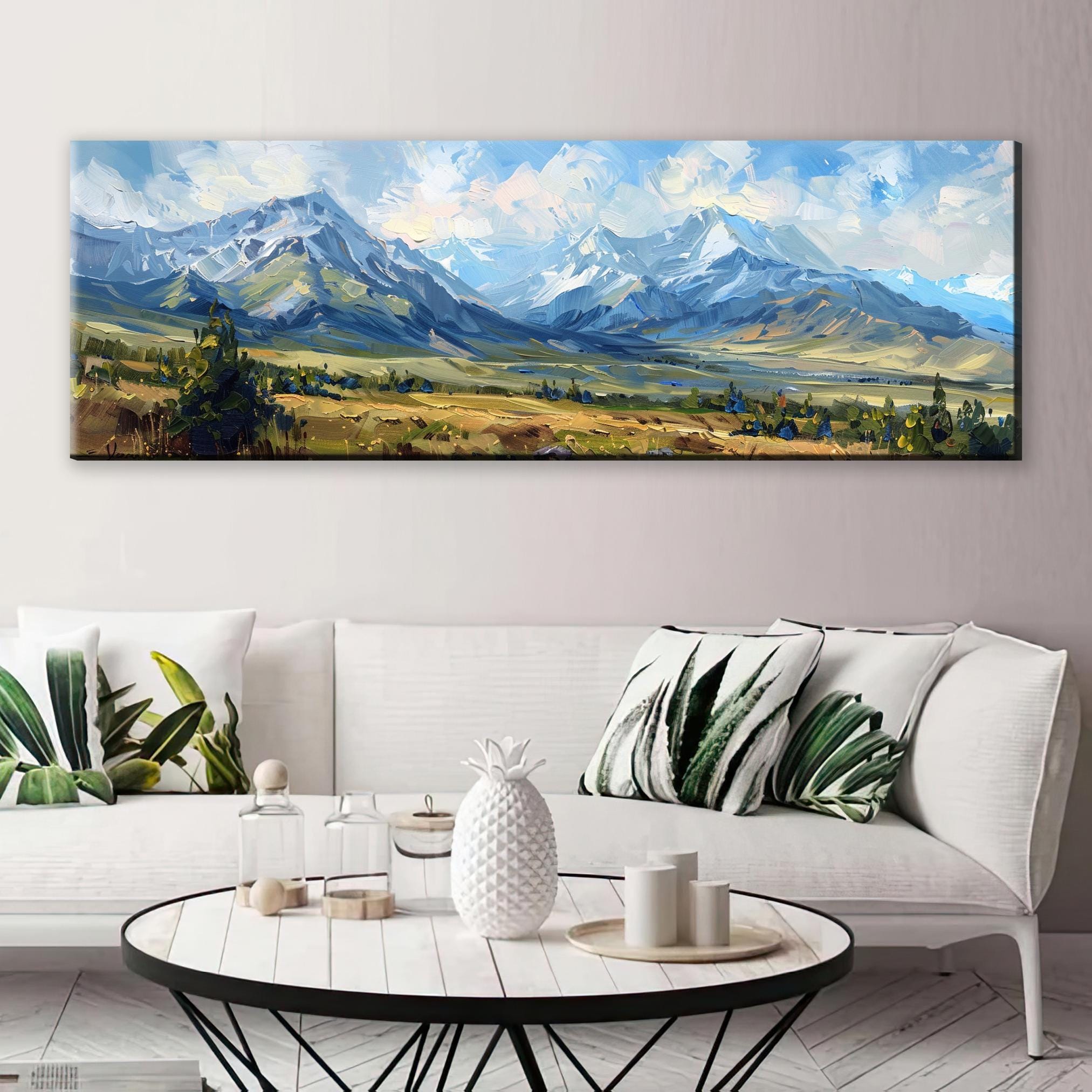 a large landscape painting hanging on a wall above a white sofa with decorative pillows.