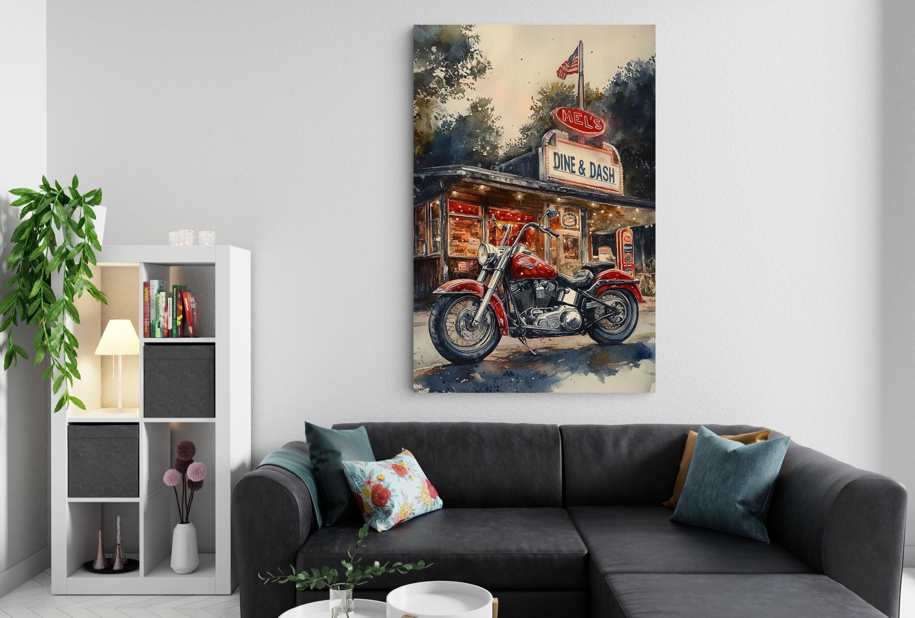 a large painting of a motorcycle parked in front of a diner, hanging on a wall above a black couch with throw pillows.