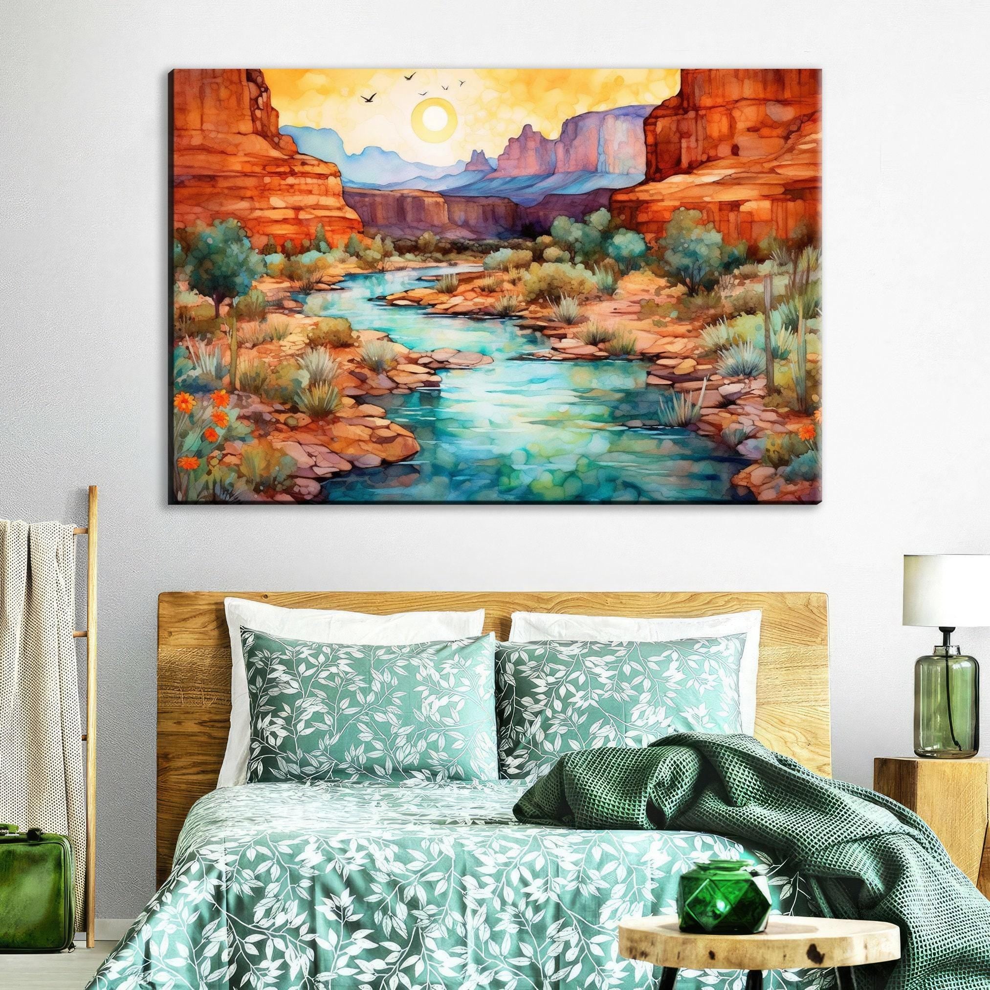 a serene bedroom scene with a large watercolor painting of a desert landscape hanging on the wall above a bed with a green and white floral bedspread.