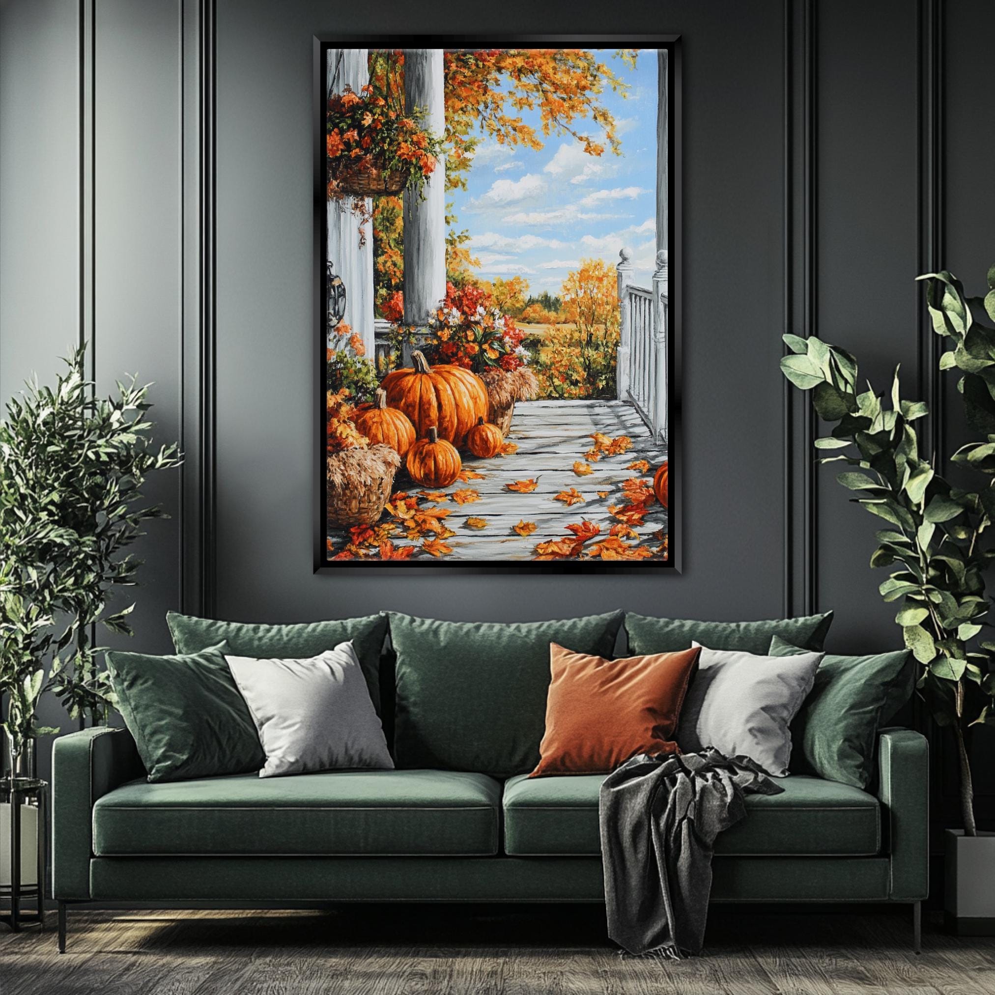 a large framed painting of a porch with pumpkins and autumn leaves, hanging on a wall above a green couch with throw pillows.