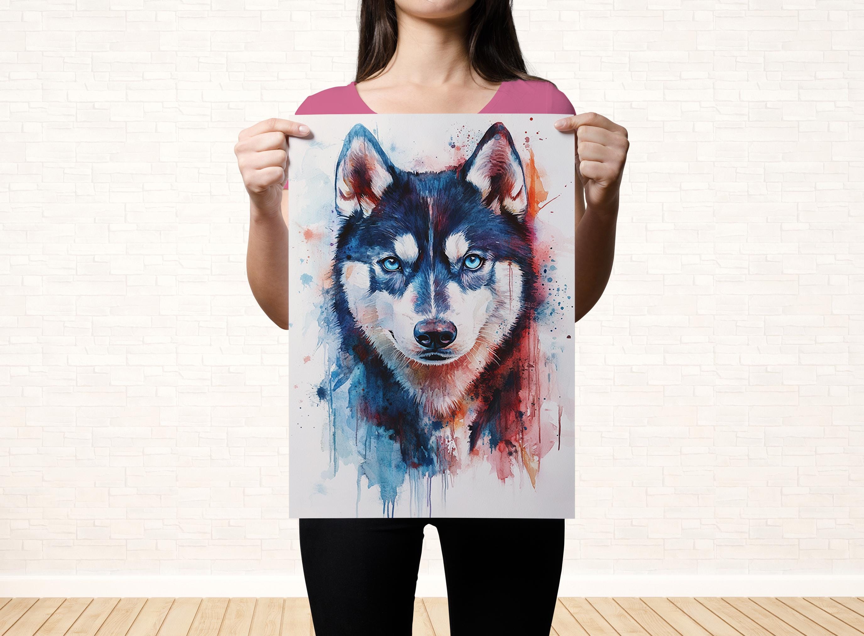 A woman is holding up a poster featuring a close-up of a wolf's face with blue eyes and a black and white color scheme.