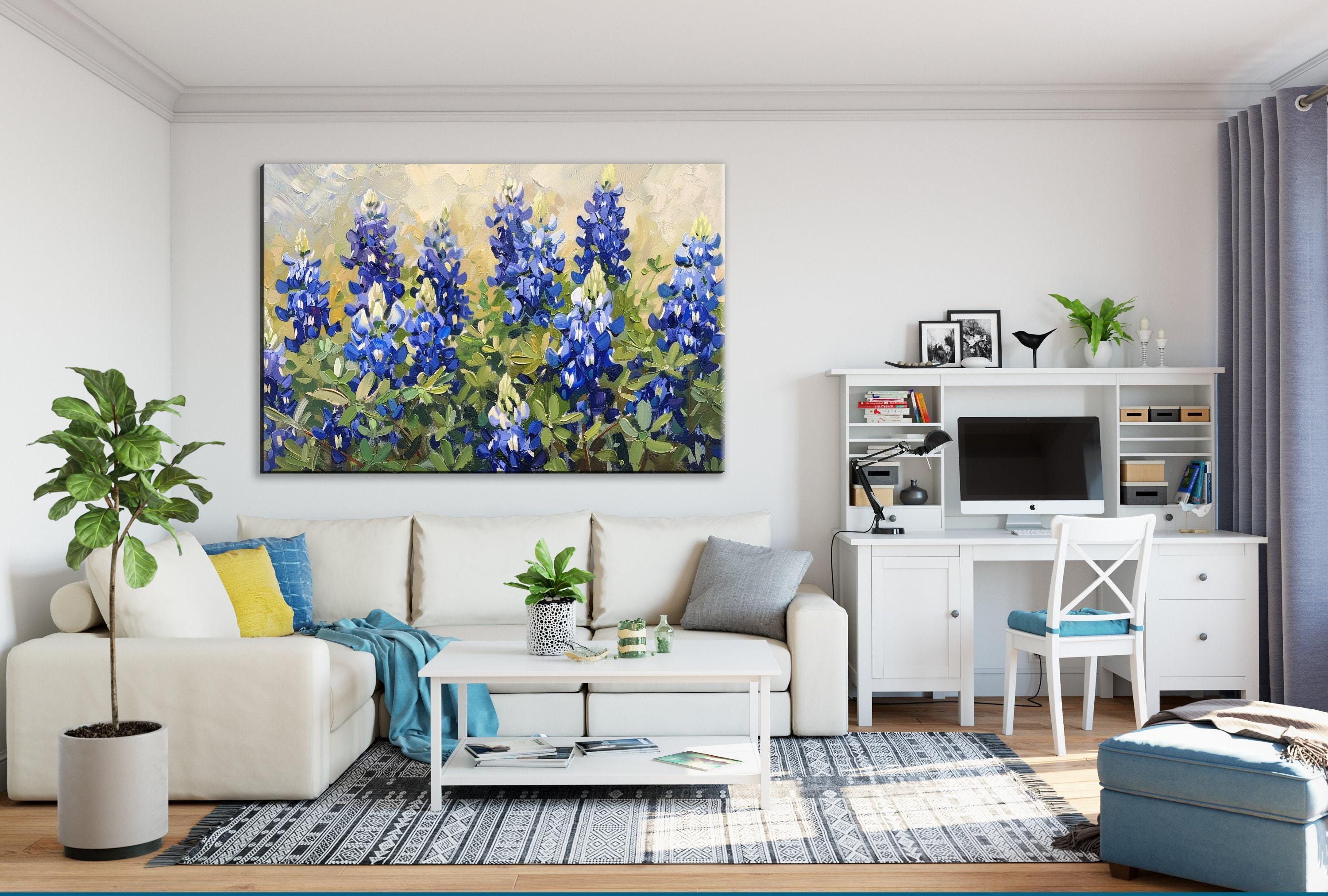 a cozy living room with a large painting of blue flowers on the wall, a white sofa, a coffee table, a desk with a computer, and various decorative elements such as plants and books.
