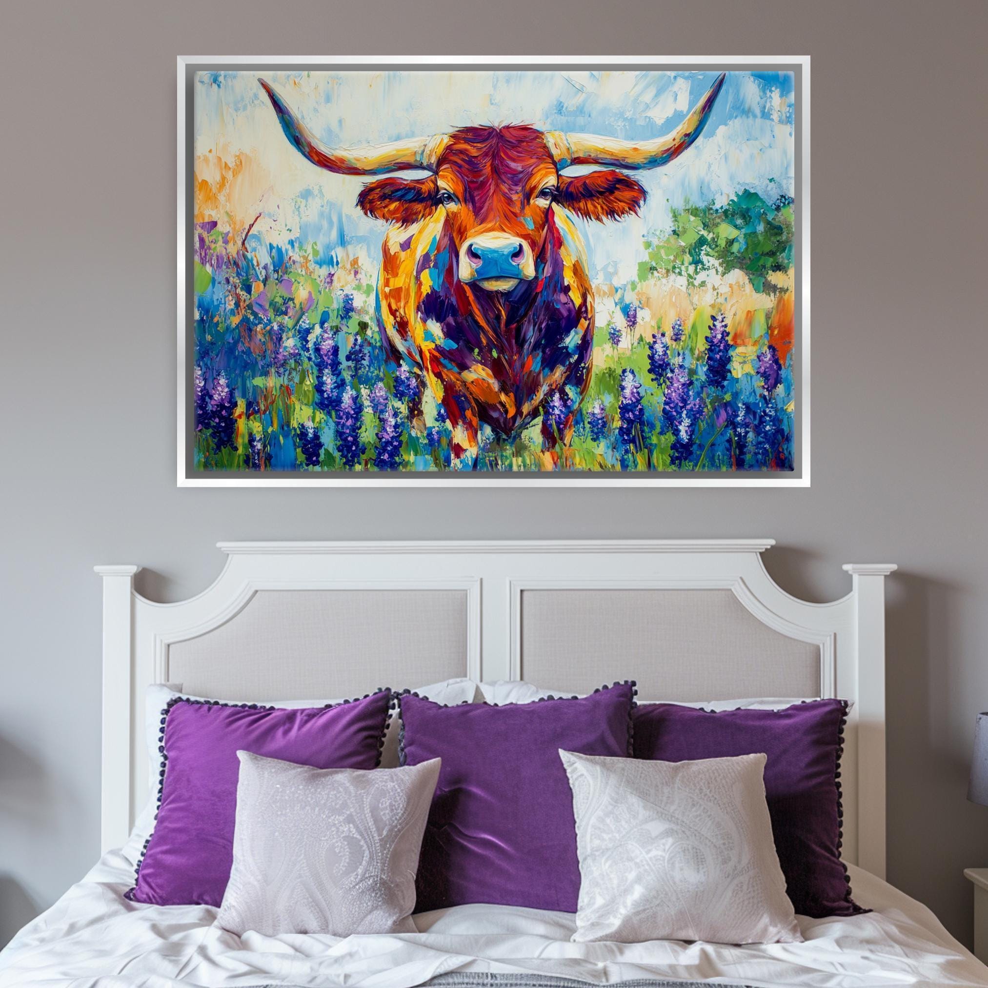 a large painting of a bull with horns, displayed above a bed with purple pillows.