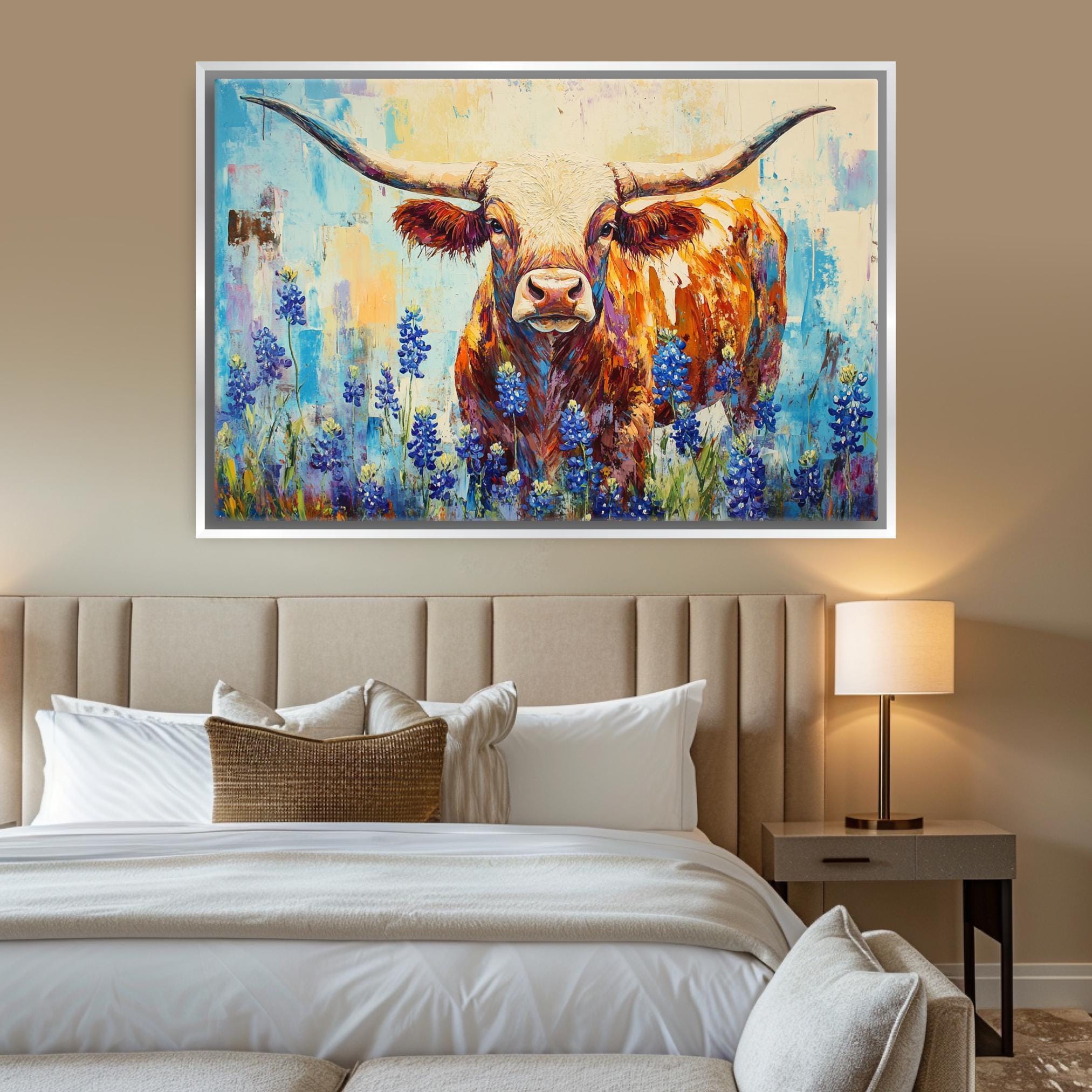 a large painting of a bull with horns, surrounded by blue flowers, hanging above a bed with white linens and a wooden headboard.