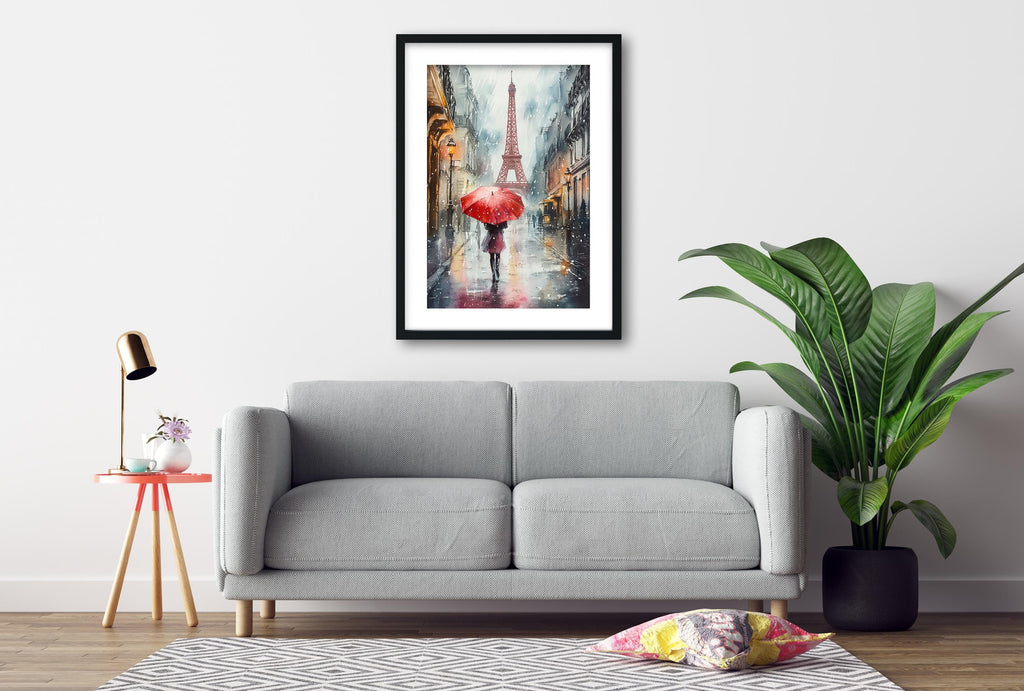 a gray sofa, a framed painting of a rainy street scene with a red umbrella, a small table with a lamp, and a potted plant.