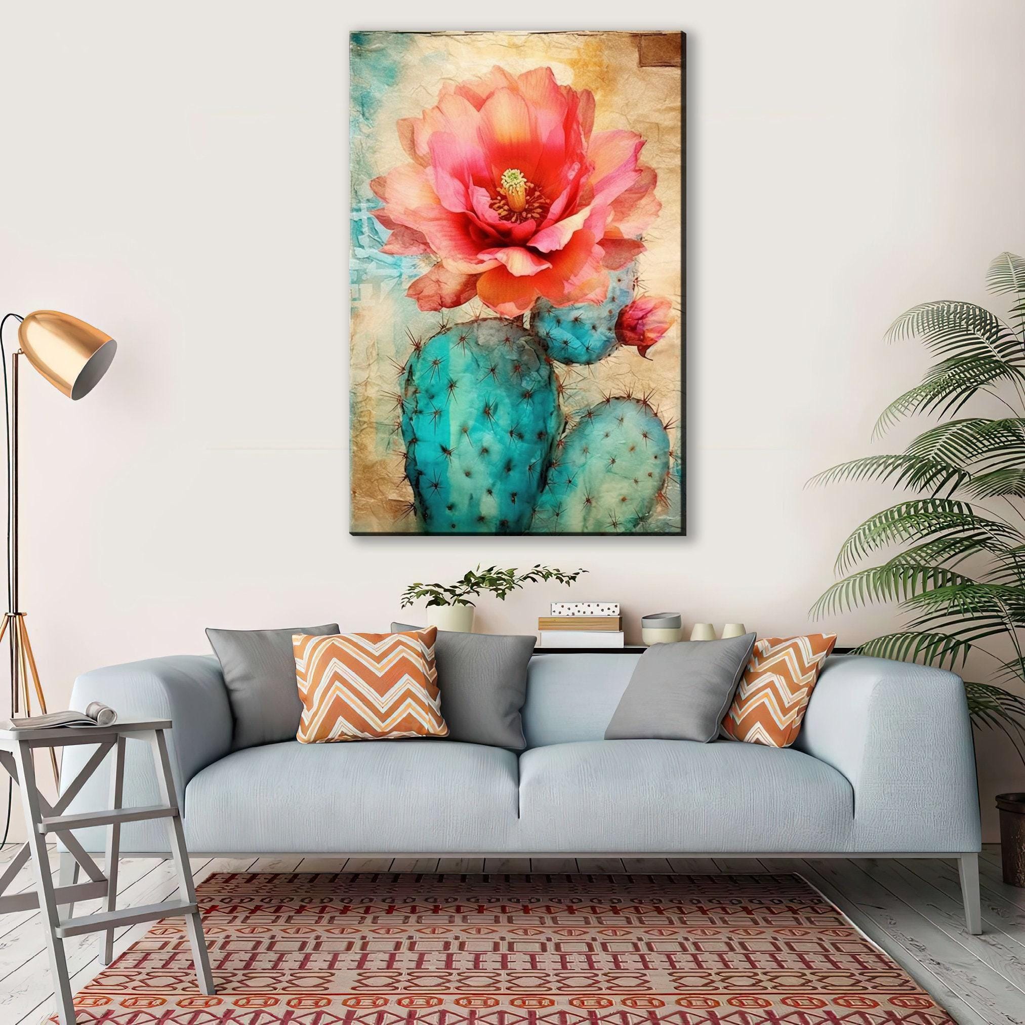 a large, vibrant painting of a cactus flower hanging on a wall above a gray couch with colorful throw pillows.