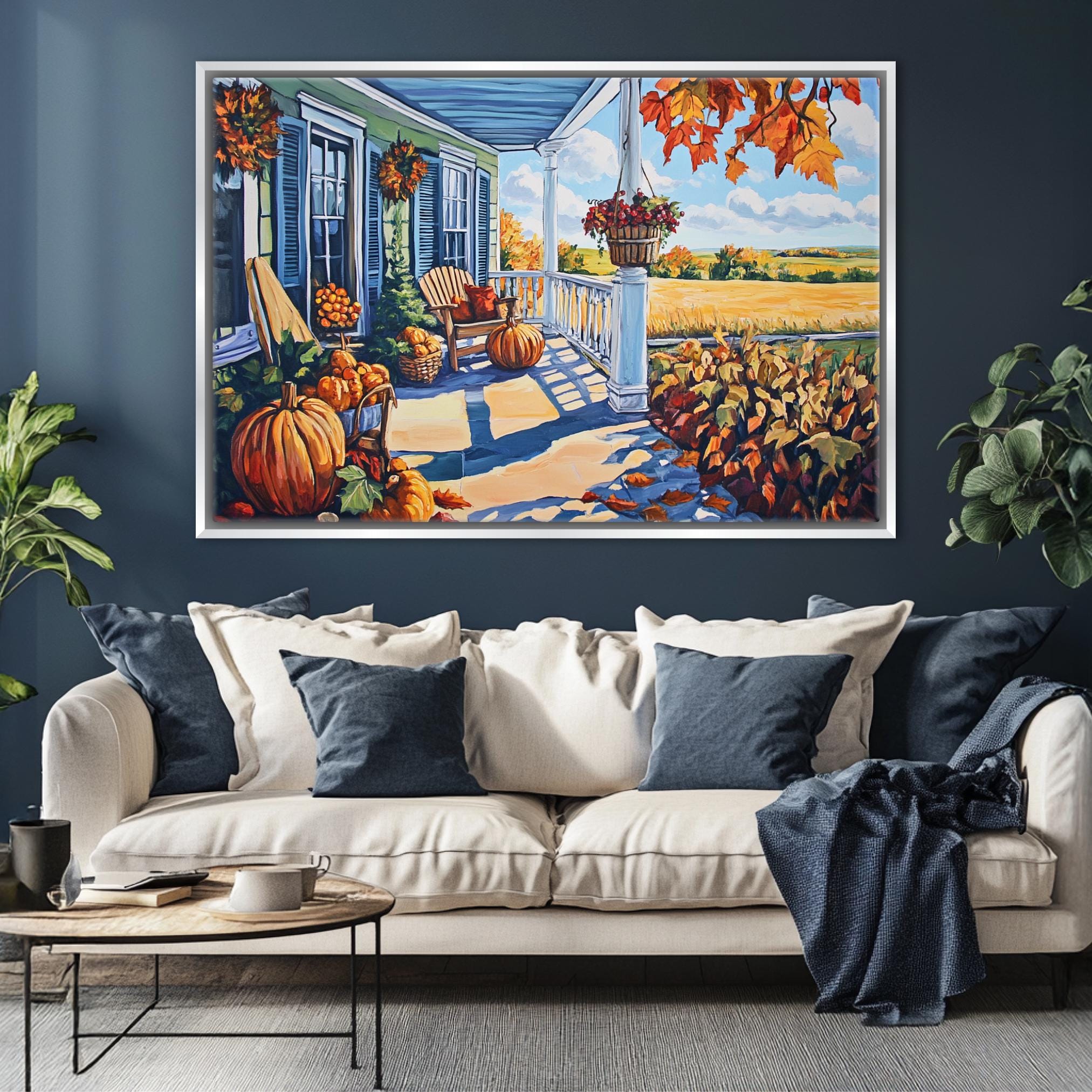 a large painting of a porch with a white sofa, blue pillows, and a pumpkin-themed decor, hanging on a blue wall above a wooden coffee table.