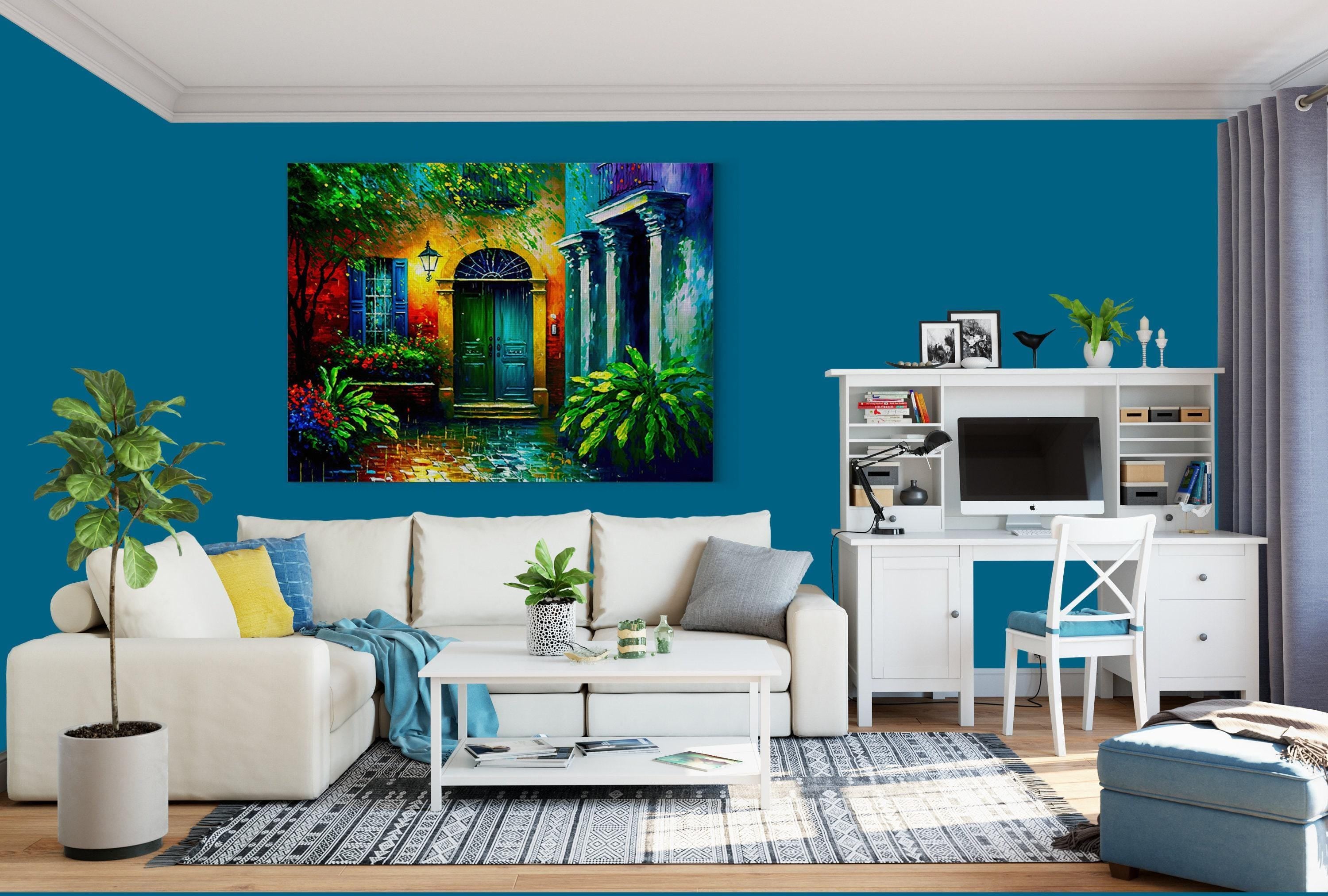 a modern living room with a large, colorful painting of a house on the wall. The room is furnished with a white sofa, a coffee table, and a desk with a computer setup. The walls are painted a bright blue color, and the room is decorated with various plants and other accessories.