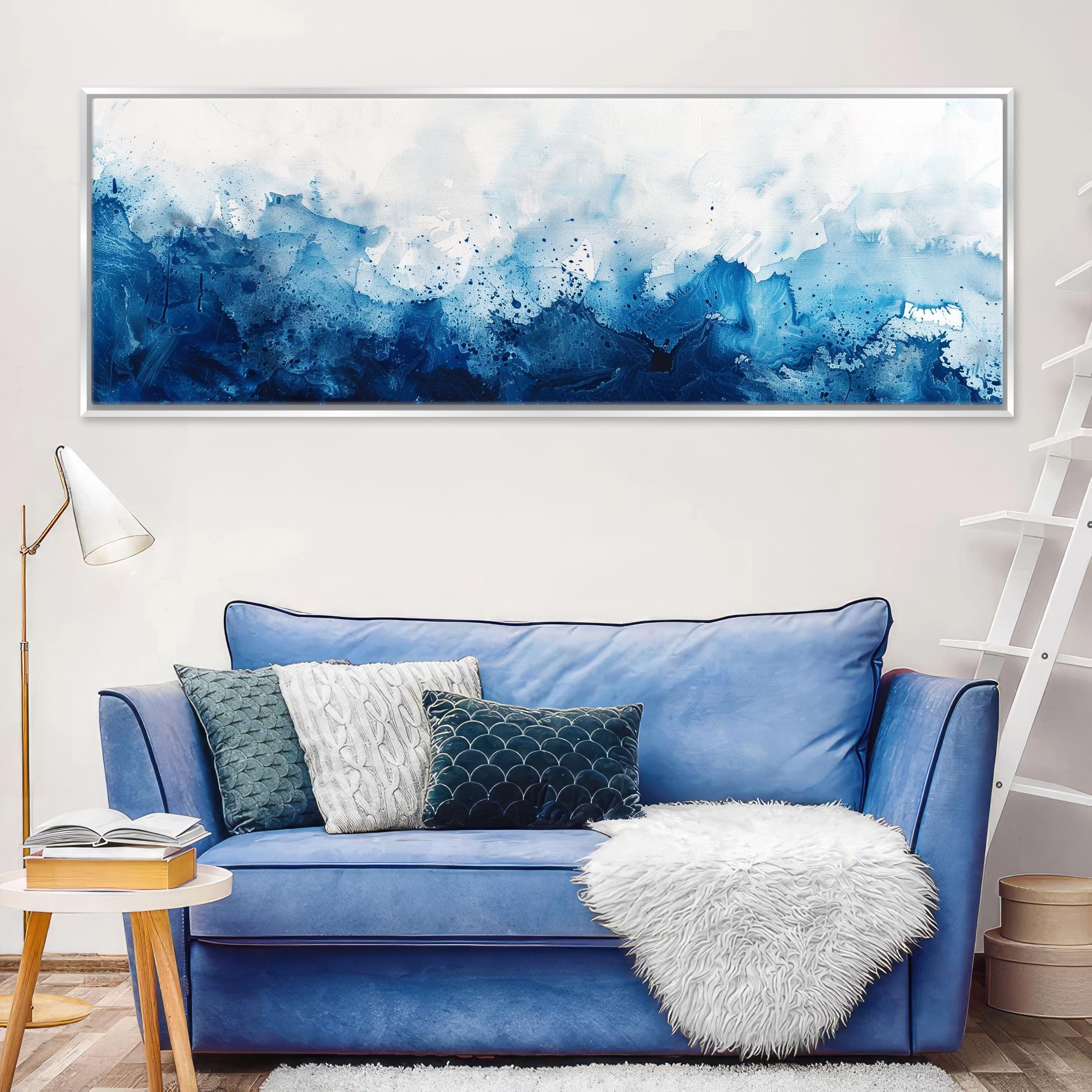 a living room with a blue couch and a painting on the wall