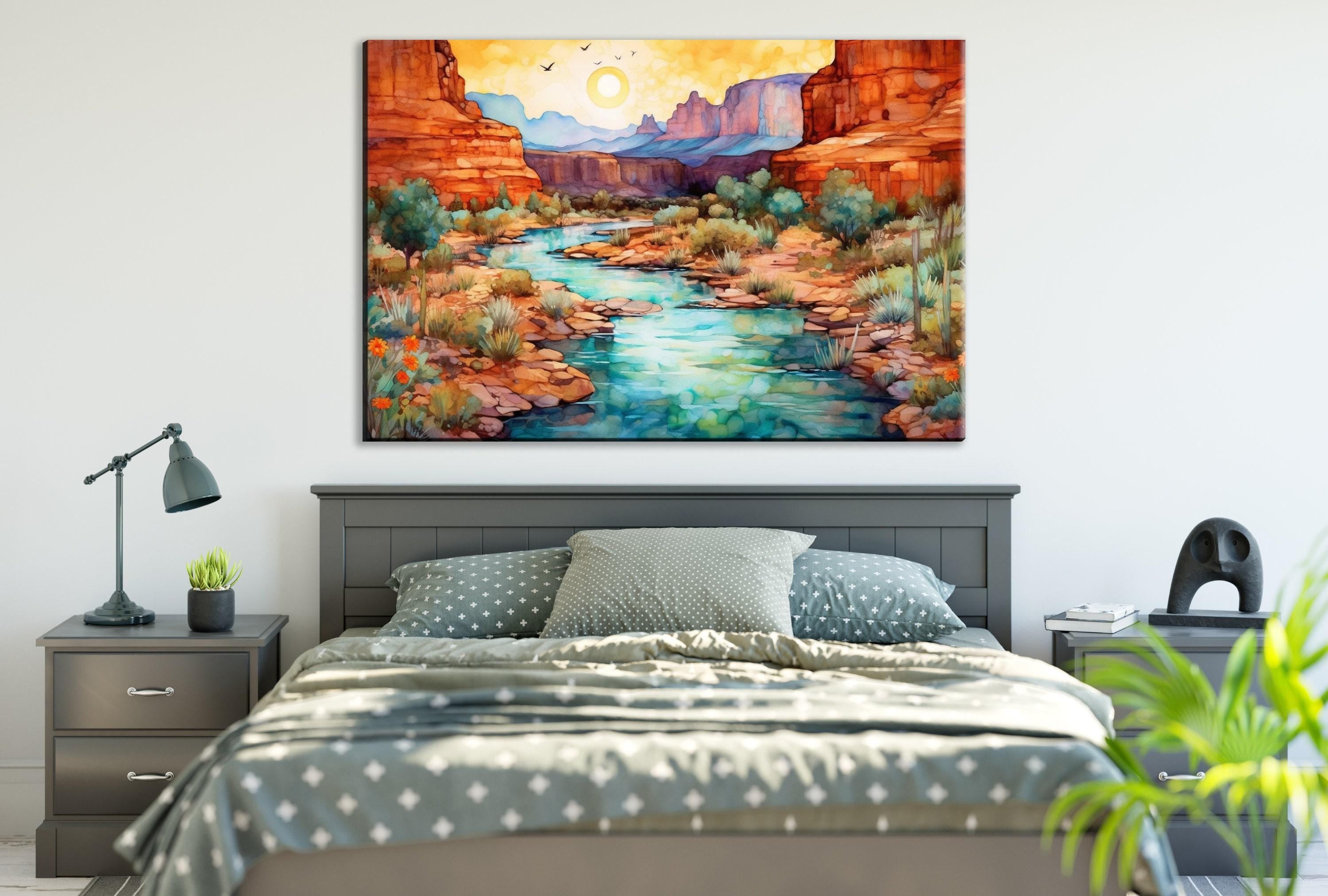 a bedroom with a large painting of a desert landscape hanging on the wall above a bed with a gray and white patterned bedspread.