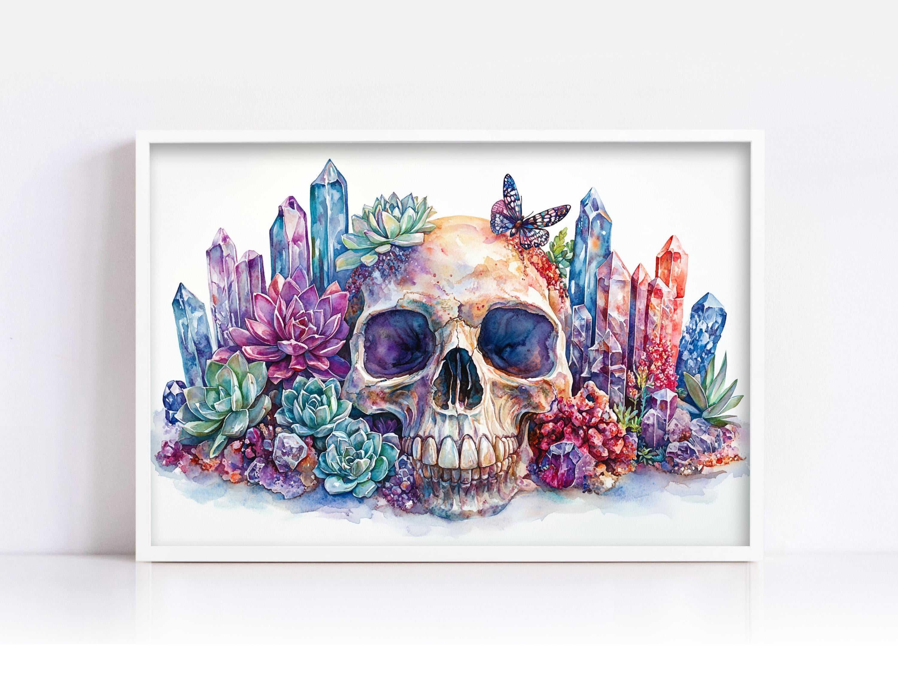 A framed watercolor painting depicting a skull surrounded by colorful crystals, succulents, and butterflies.