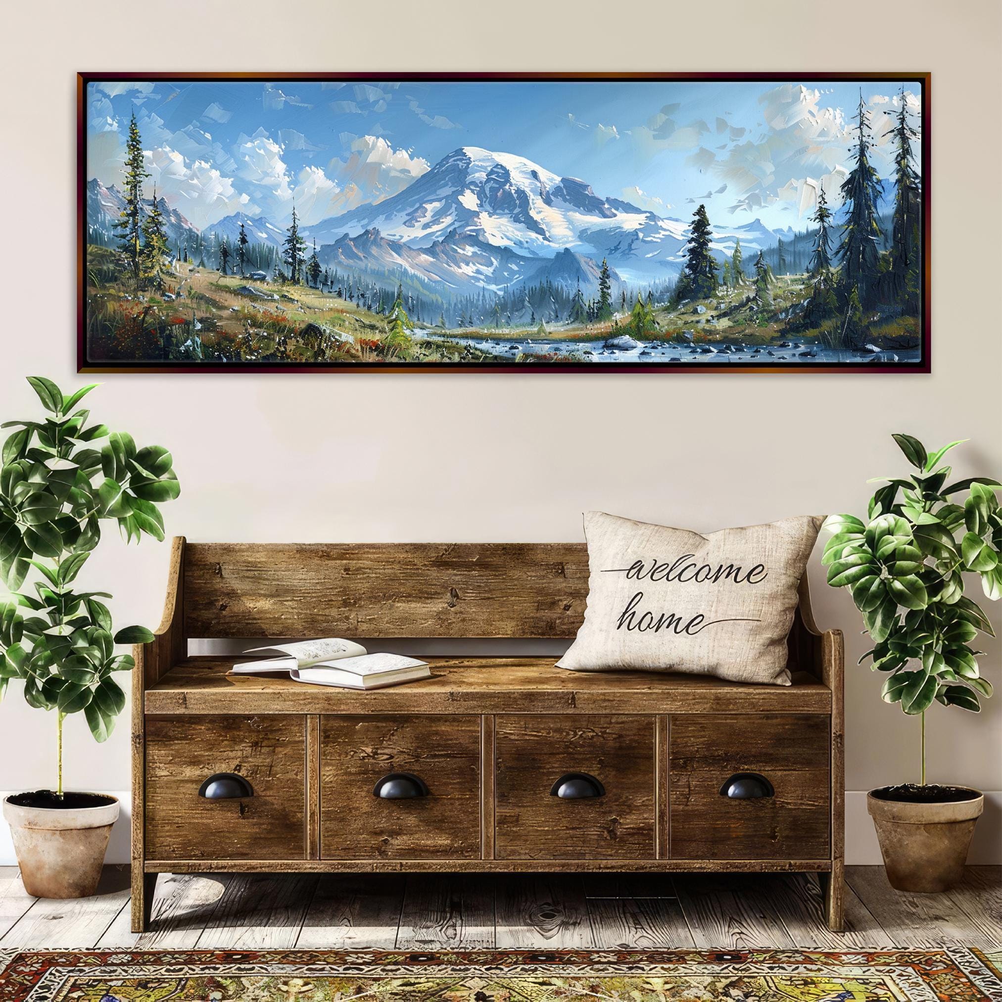 a large wooden bench with a "welcome home" pillow, surrounded by potted plants and a framed landscape painting depicting a mountain and forest scene.