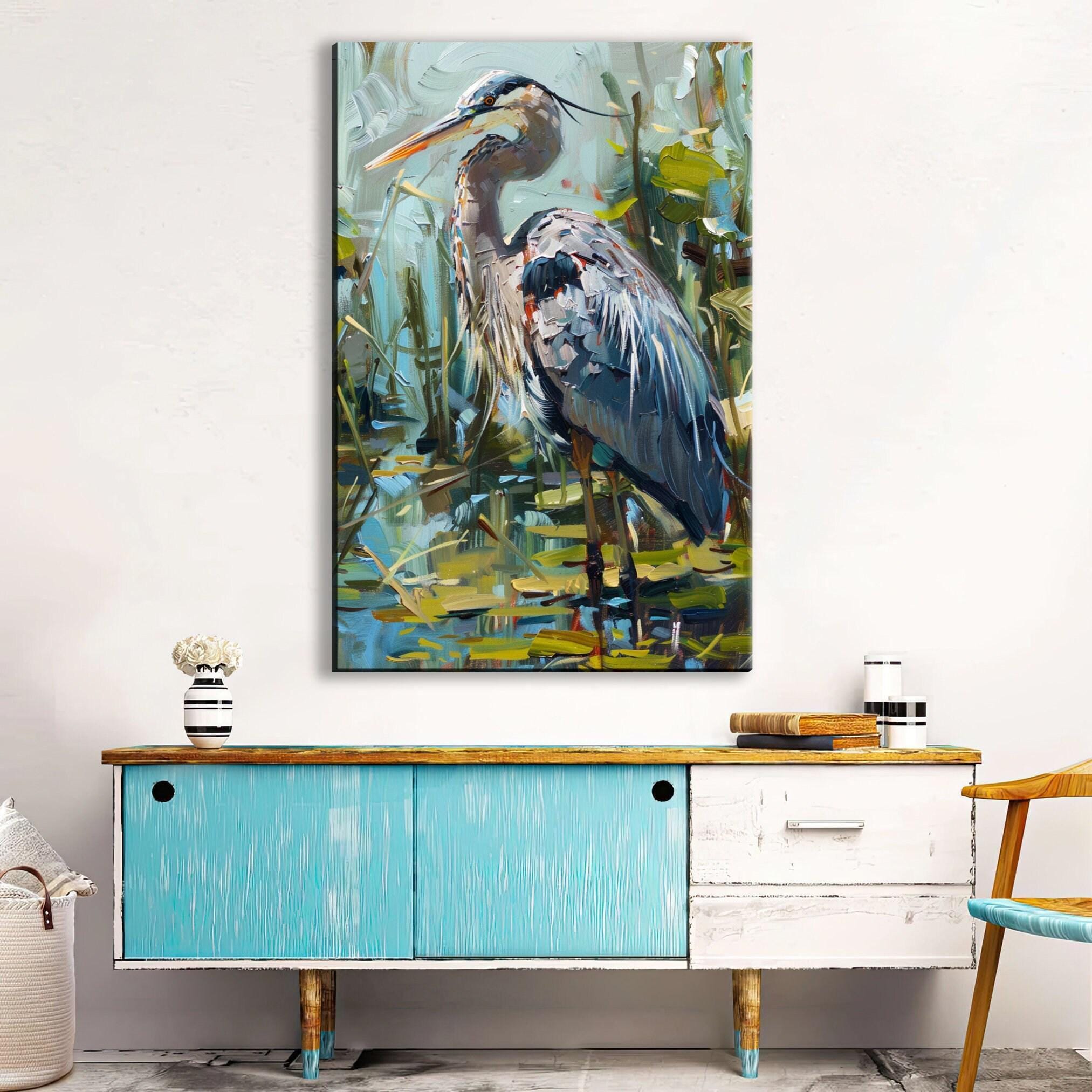 a large painting of a blue heron standing in a pond, hanging on a wall above a blue cabinet with a white top.
