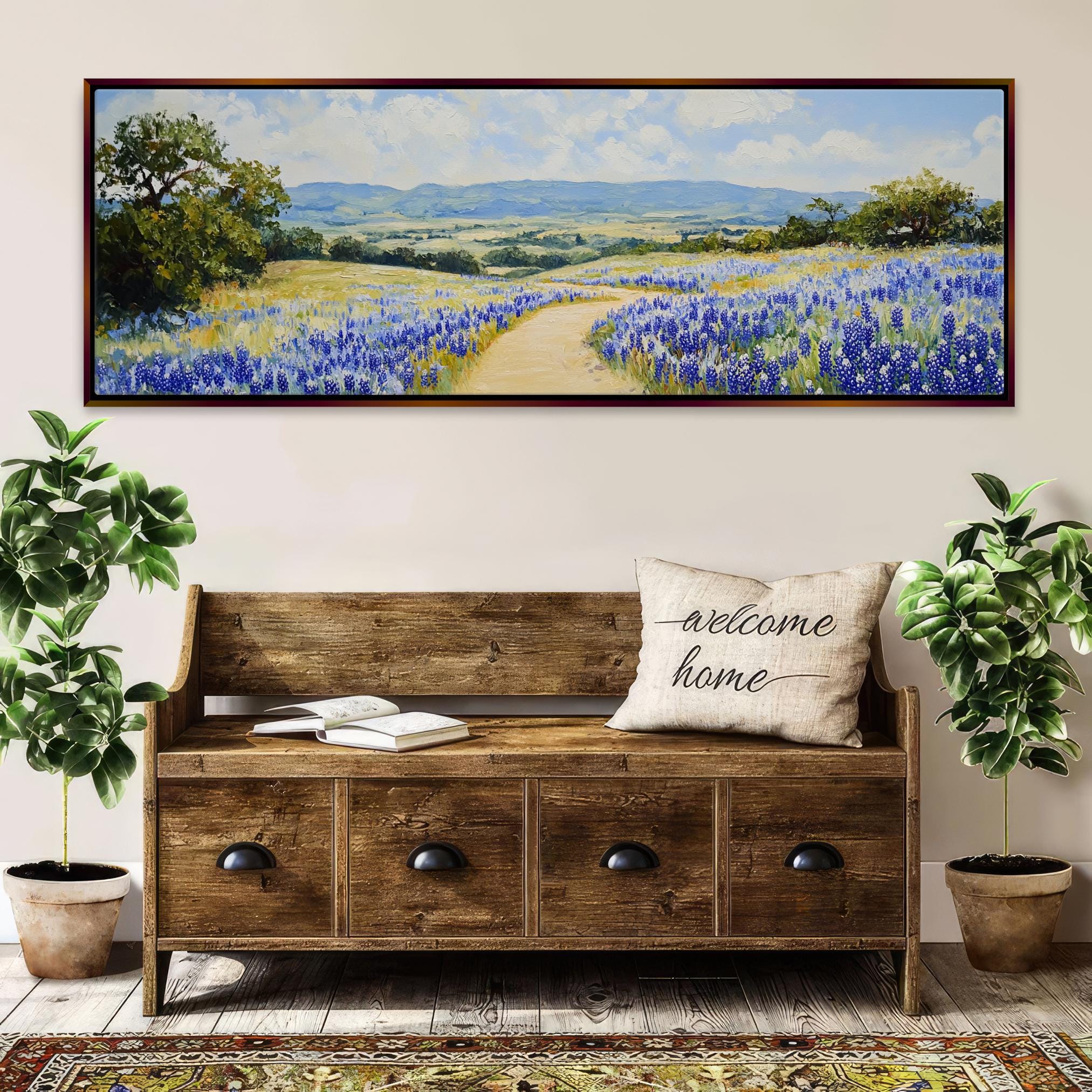 a painting of a field of bluebonnets hangs above a bench