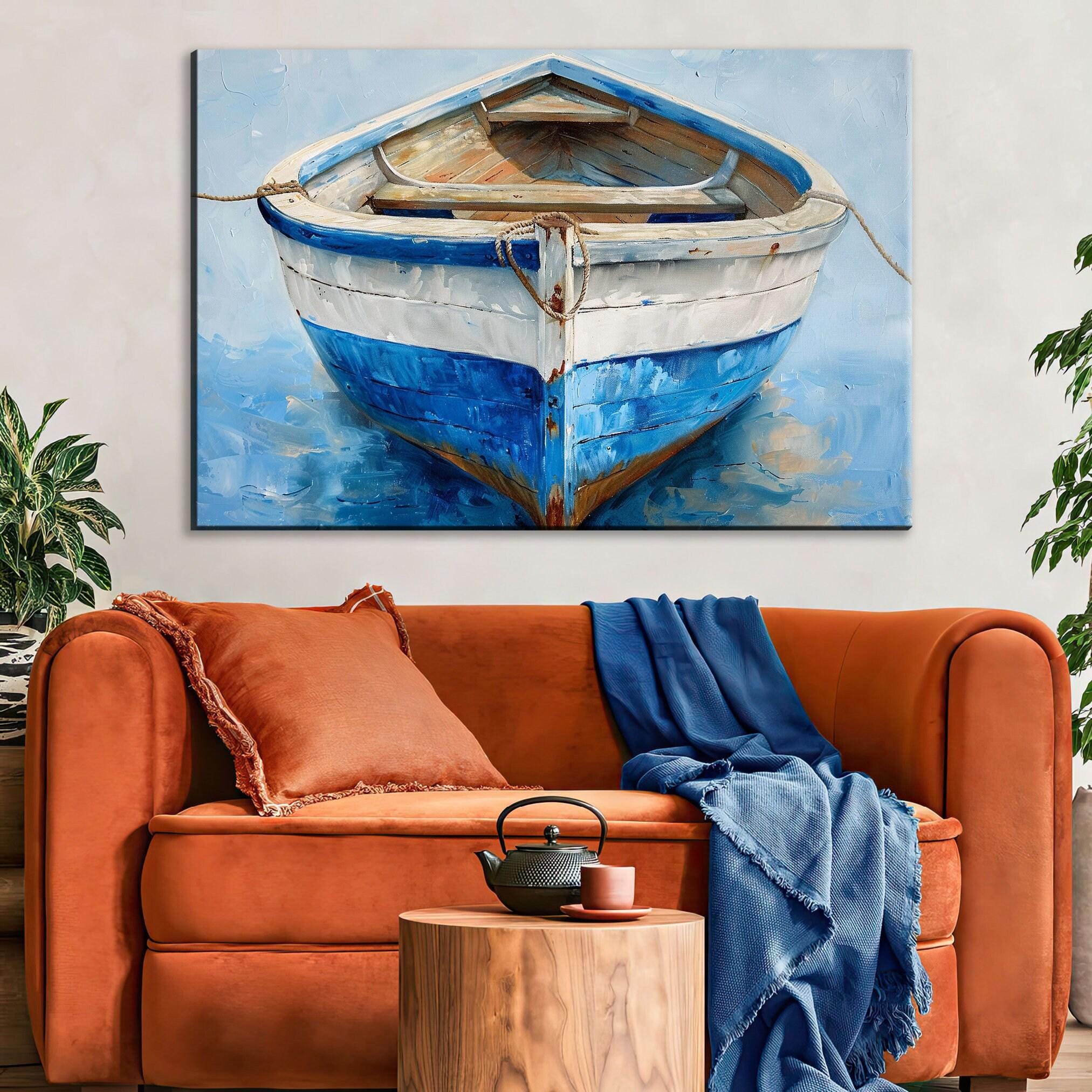 a cozy living room with a large painting of a blue and white striped boat hanging on the wall above a comfortable orange sofa. The sofa is adorned with a blue blanket and a black teapot, creating a warm and inviting atmosphere.