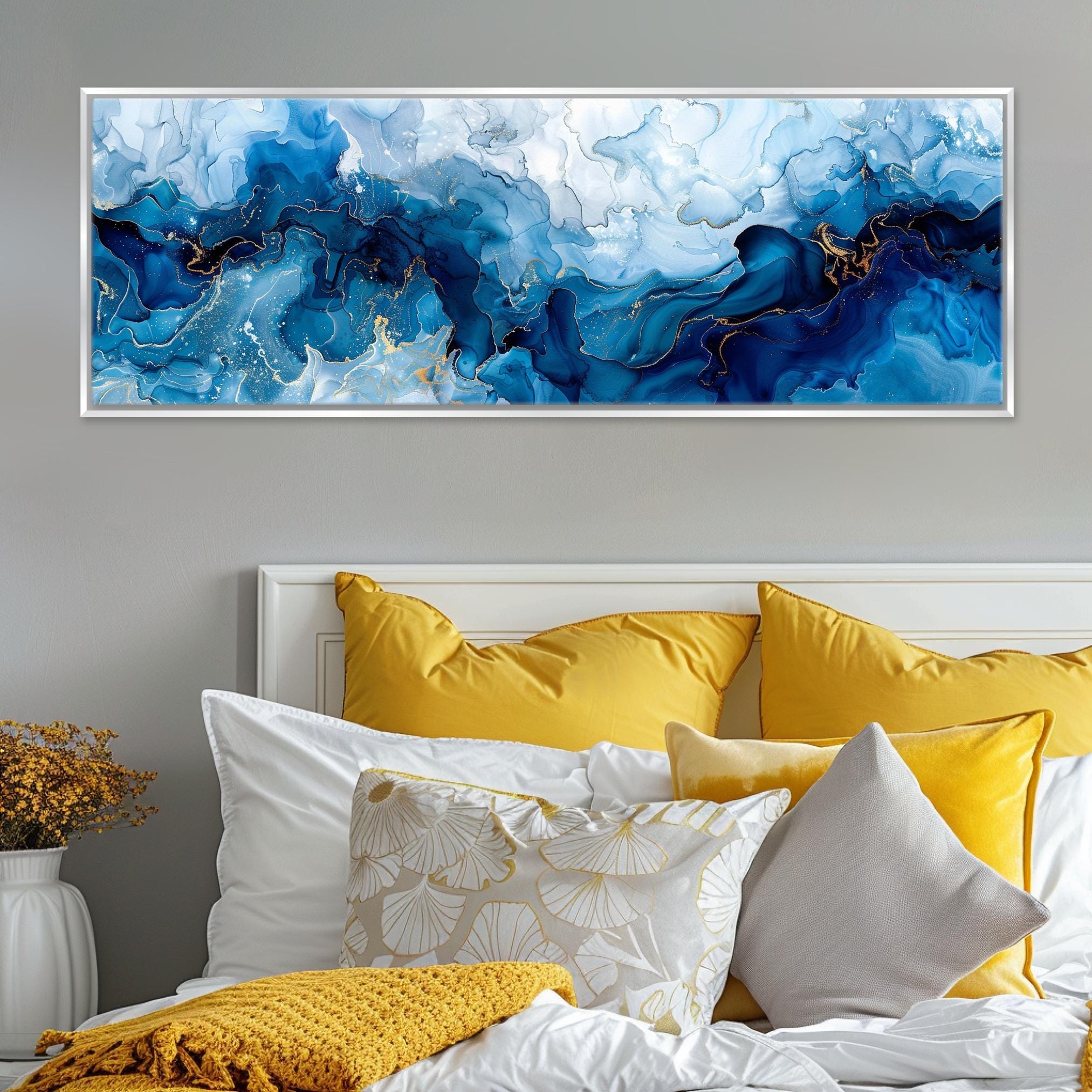 a bed with a white headboard and yellow pillows