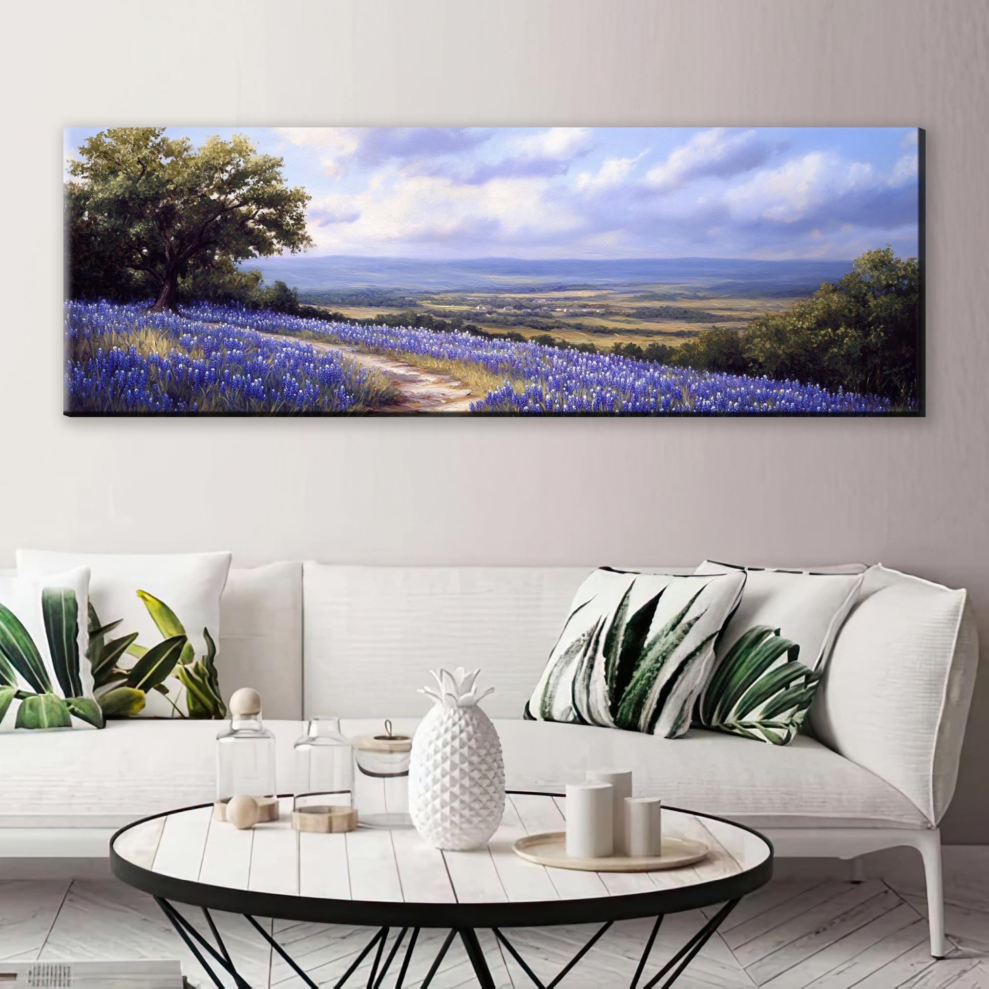 a living room with a white couch and a painting on the wall