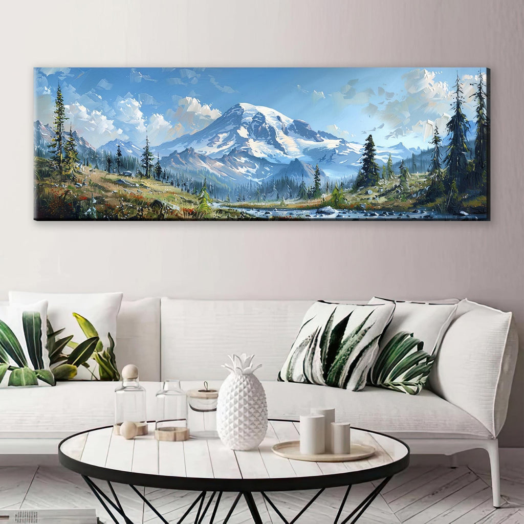 a large landscape painting depicting a snowy mountain range with pine trees and a river, hanging on a wall above a white sofa with decorative pillows.