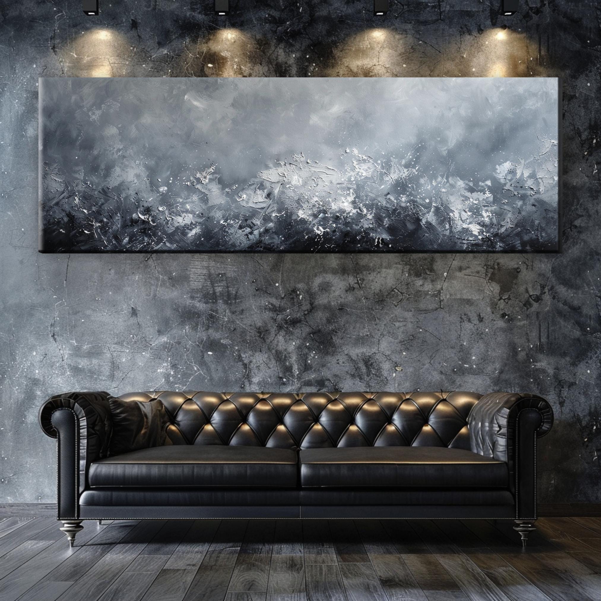 a black leather couch sitting in front of a painting