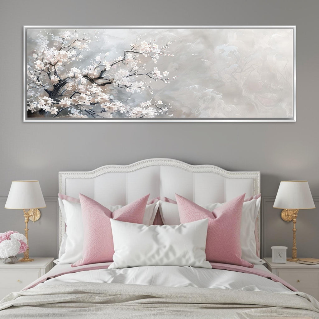 a white bed with pink pillows and a painting on the wall
