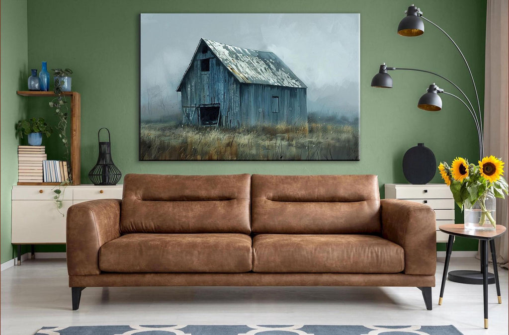 a large painting of a barn in a field hanging on a green wall above a brown leather couch in a living room setting.