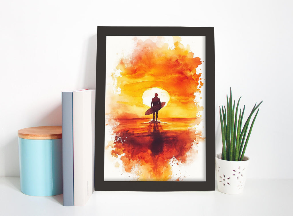 a framed painting of a surfer holding a surfboard, set against a vibrant sunset backdrop. The painting is displayed on a white wall, with a blue container, a white vase, and a plant to the side.