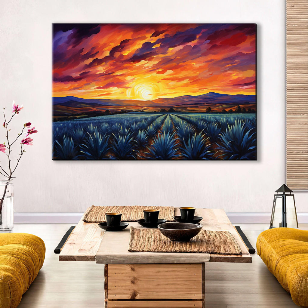 a large painting of a sunset over a field of blue flowers, hanging on a wall above a wooden coffee table with a bowl and cups on it.