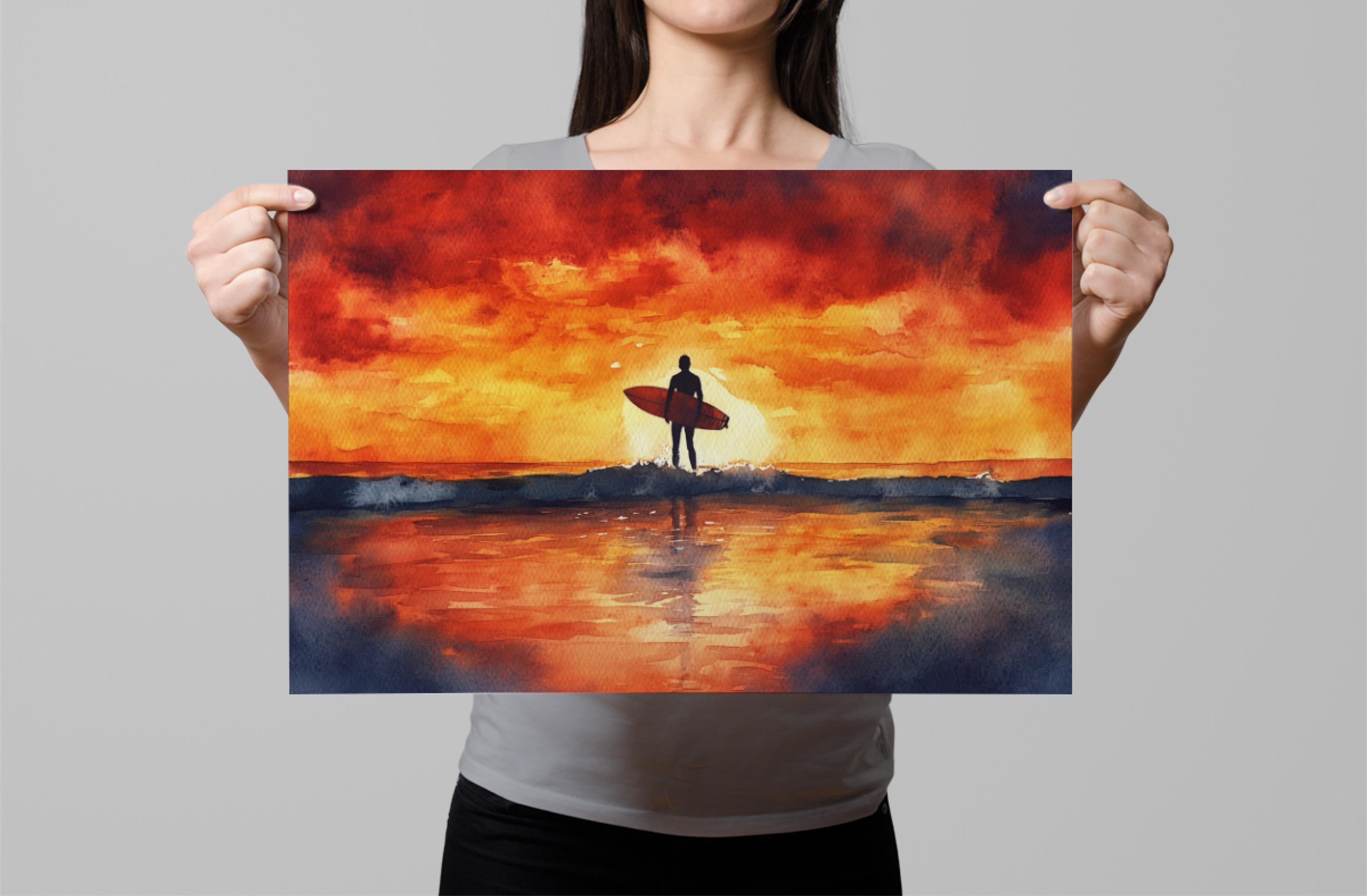 A woman holds up a framed print depicting a surfer standing on a beach, with a vibrant sunset in the background.