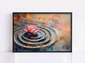 A framed painting depicting a pink lotus flower floating on a rippled surface, surrounded by a colorful abstract background.