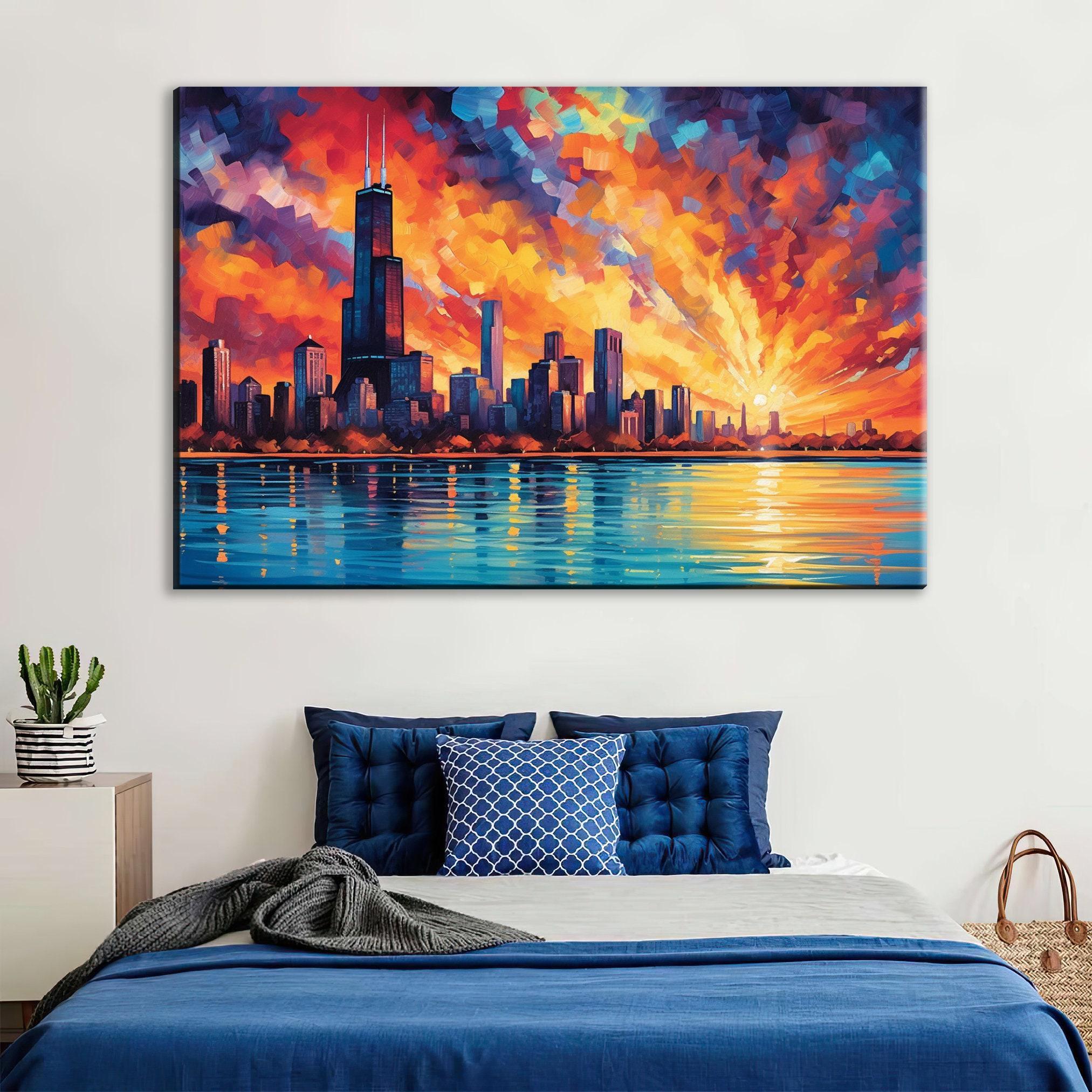 a large painting of a city skyline with a sunset over the water, hanging on a wall above a bed with blue bedding and pillows.