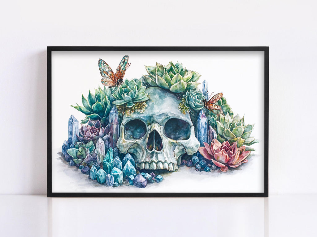 A framed watercolor painting depicting a skull surrounded by a variety of colorful plants, including succulents, flowers, and butterflies.