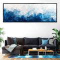 a living room with a couch and a painting on the wall