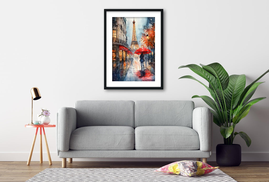 a gray sofa, a framed painting of a rainy city street with a tall tower, a red umbrella, and a potted plant, all set against a white wall.