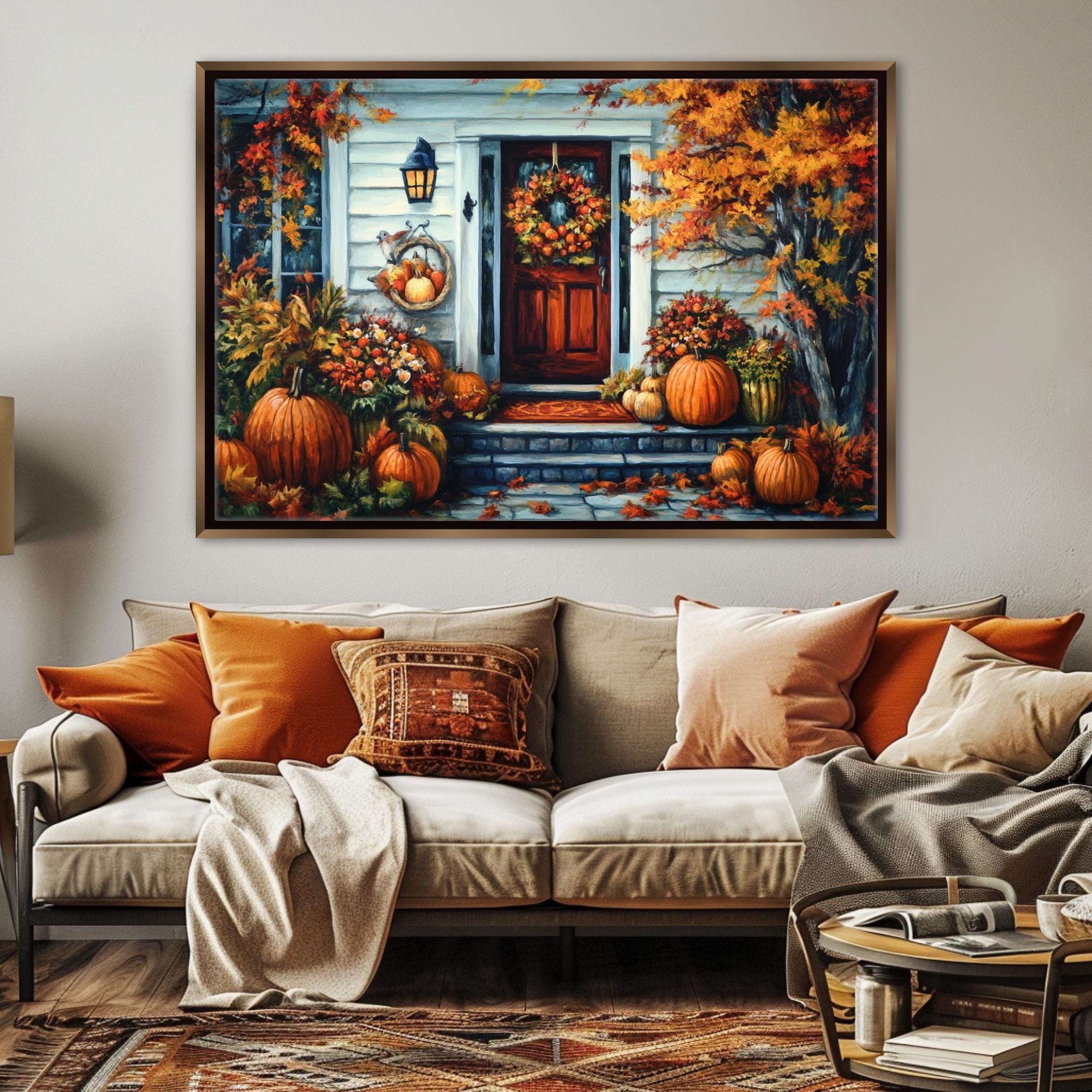 a cozy living room with a large painting of a house and autumn decorations hanging on the wall above a beige sofa adorned with orange and beige pillows.
