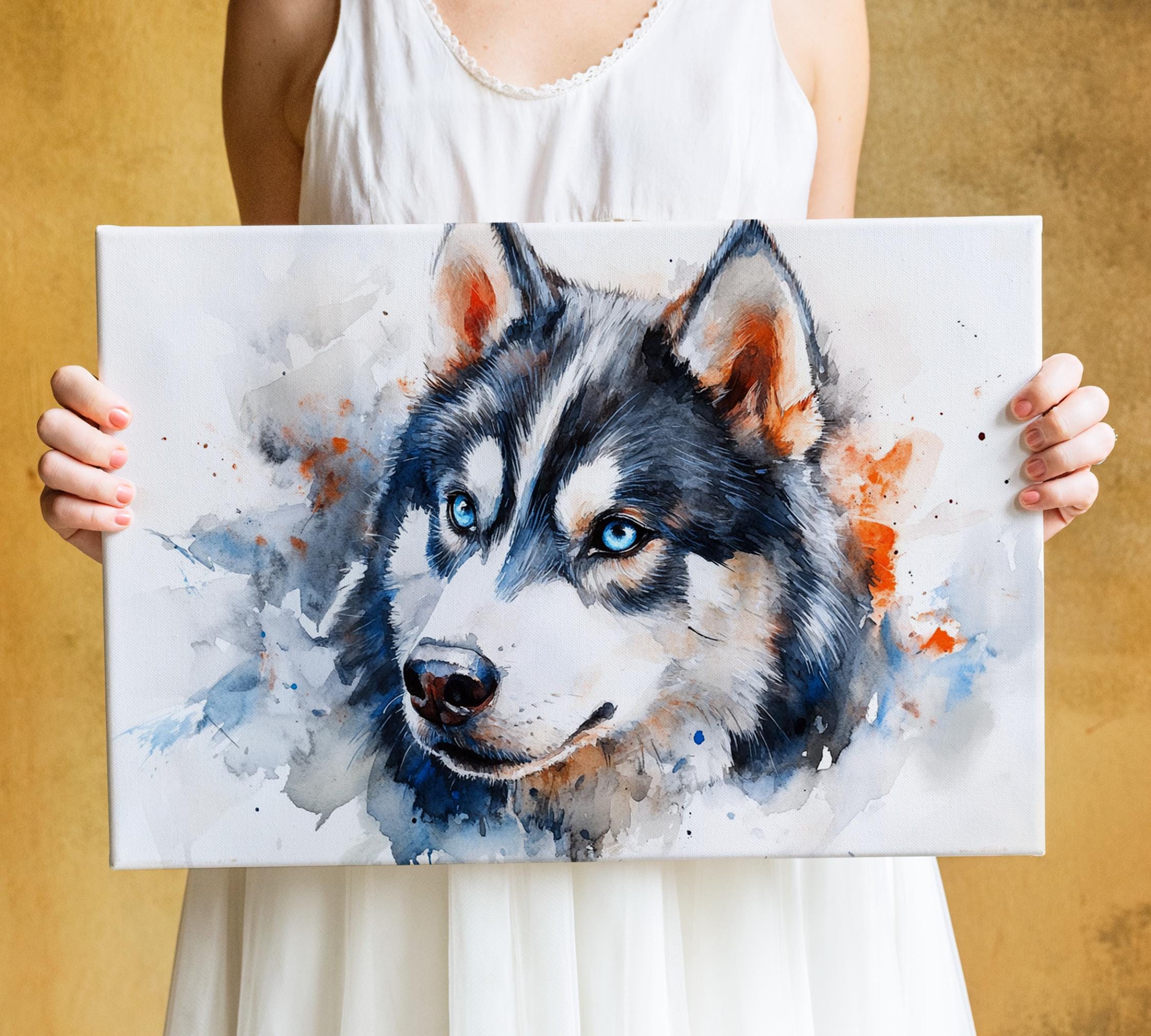 A person is holding a canvas print of a close-up of a husky dog's face, which is painted in a watercolor style with splashes of blue and orange.