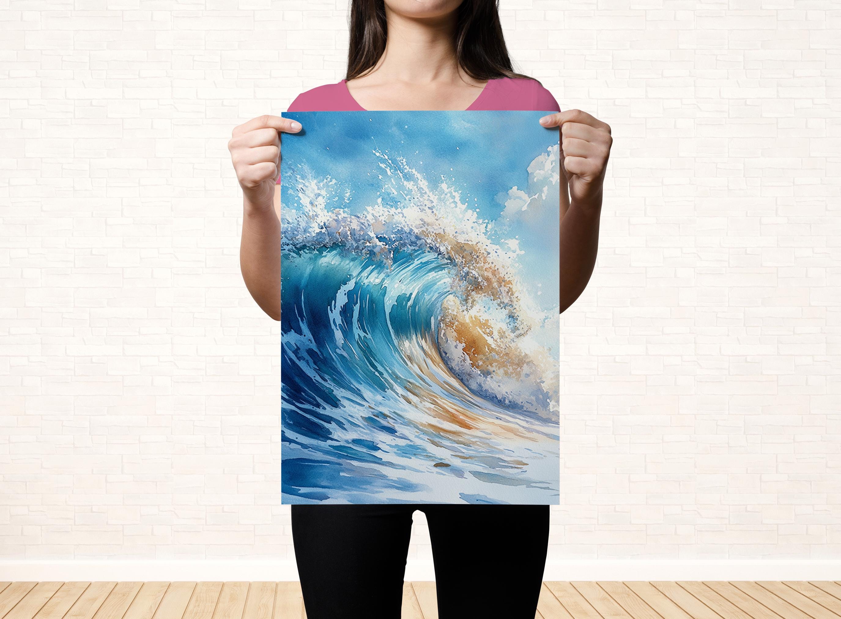 A woman holds up a large poster of a crashing wave against a white brick wall.