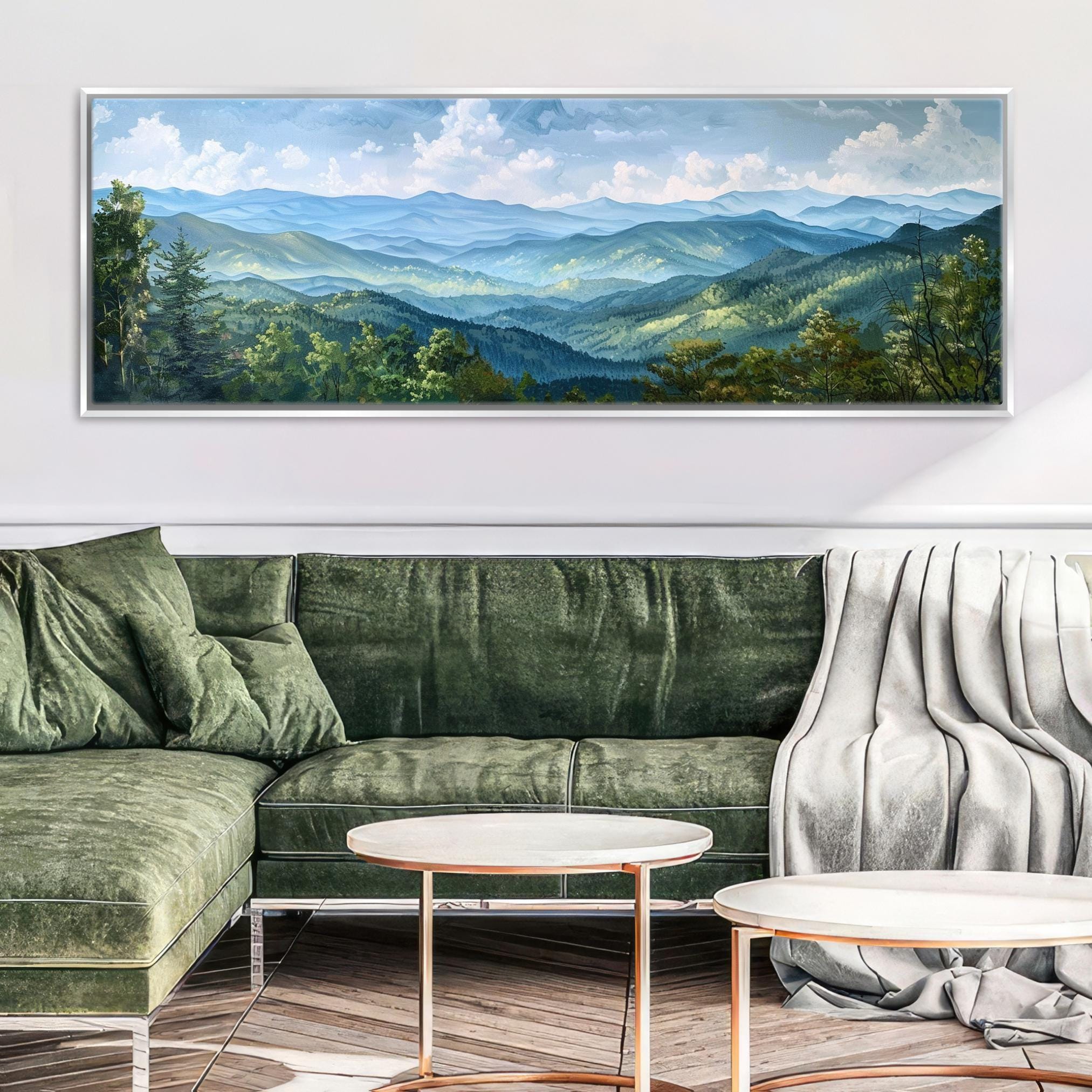a large landscape painting hanging on a wall above a green sofa in a living room setting.