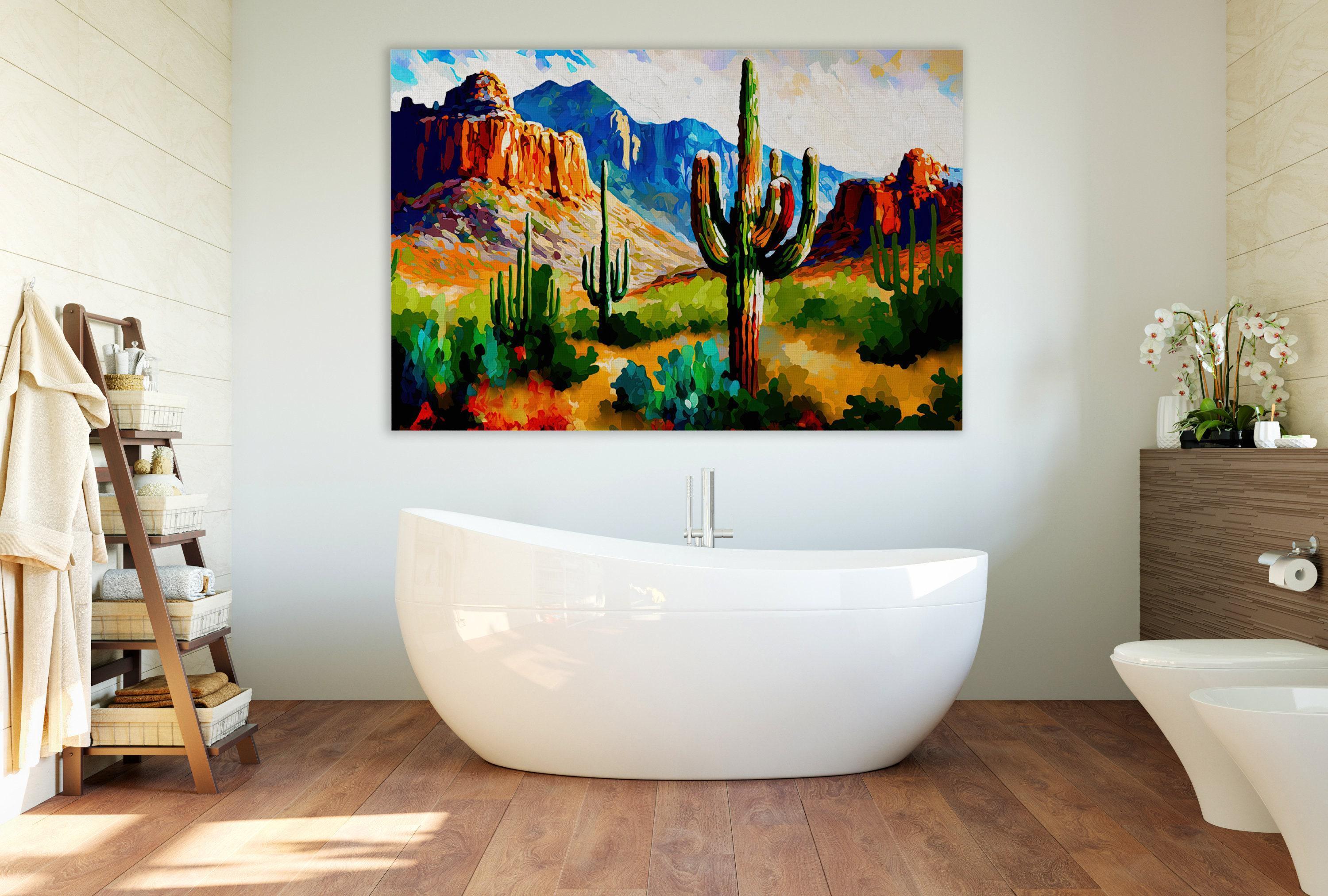 a bathroom with a large painting of a desert landscape hanging on the wall above a freestanding bathtub.