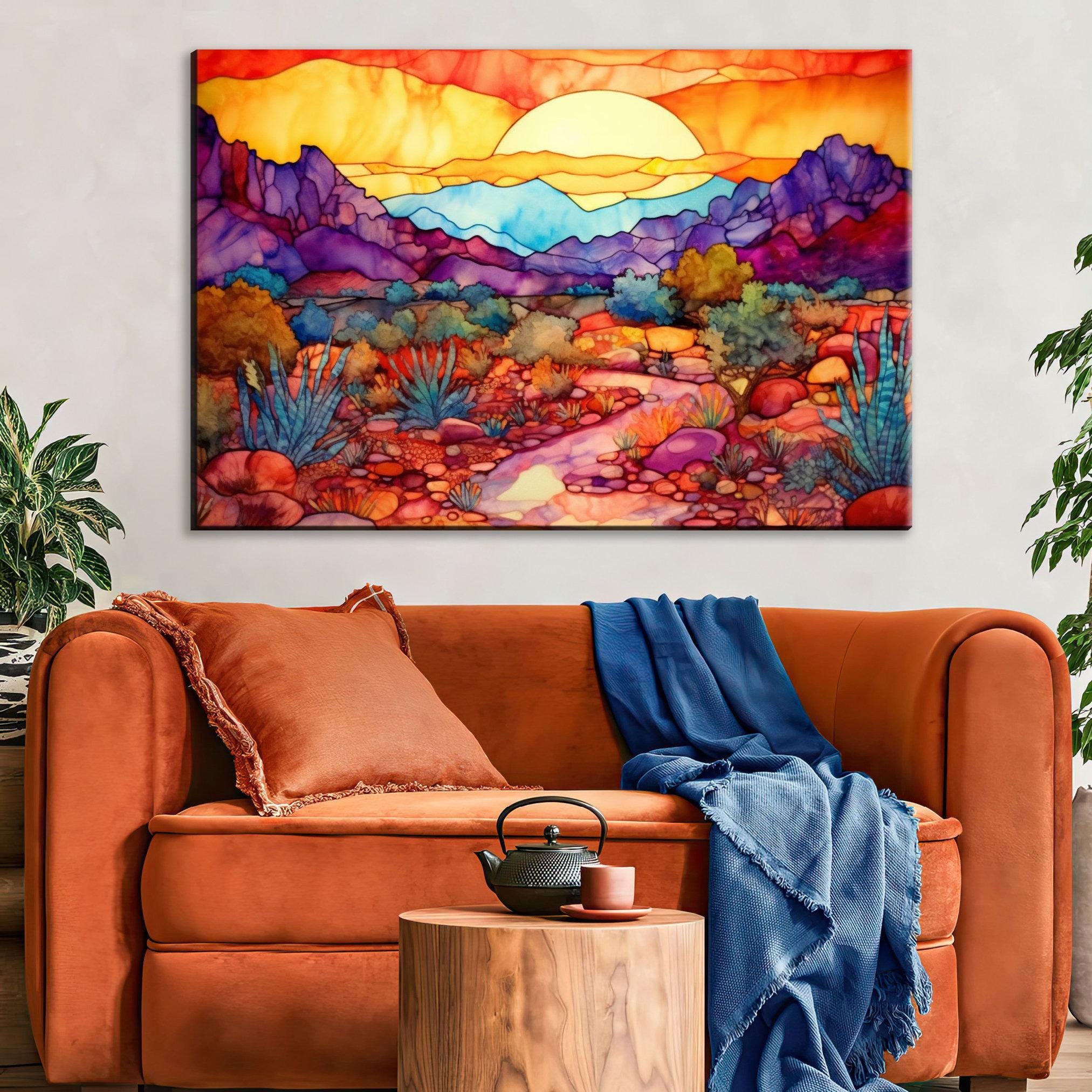 a vibrant, colorful painting of a desert landscape hanging on a wall above a cozy living room setting with a brown sofa and a wooden side table.