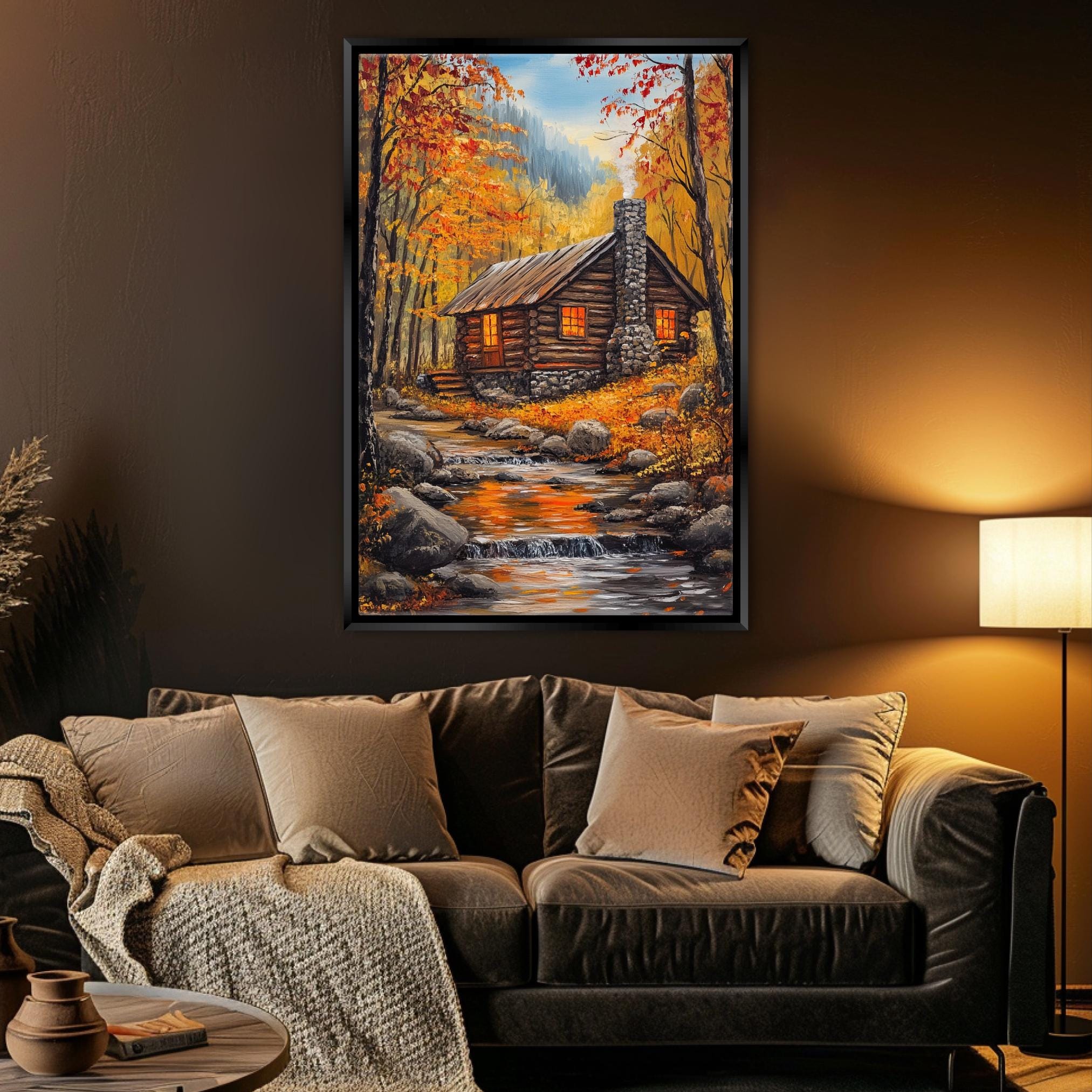 a cozy living room with a large painting of a cabin nestled in a forest, surrounded by autumn foliage. The painting is hung on the wall above a comfortable couch with plush pillows. The room is warmly lit, creating a welcoming atmosphere.