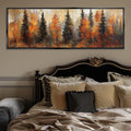 a large painting of a forest with autumn-colored trees hanging above a bed with a black headboard and beige bedding.