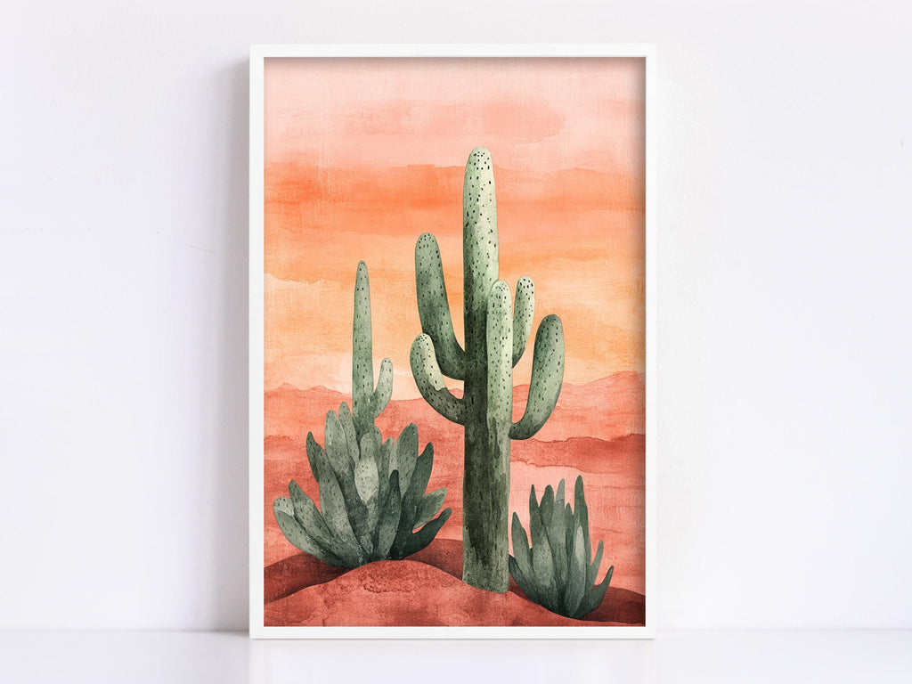 A framed watercolor painting depicting a desert landscape with three cacti against a warm orange and red background.